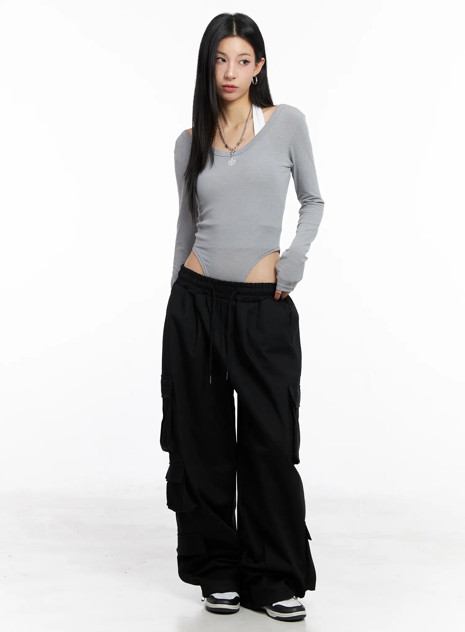 Wide Leg Cargo Pants CC1109 in black, front full-body shot on model, elastic drawstring waist, multiple stacked cargo pockets, paired with grey crop long-sleeve top and sneakers.