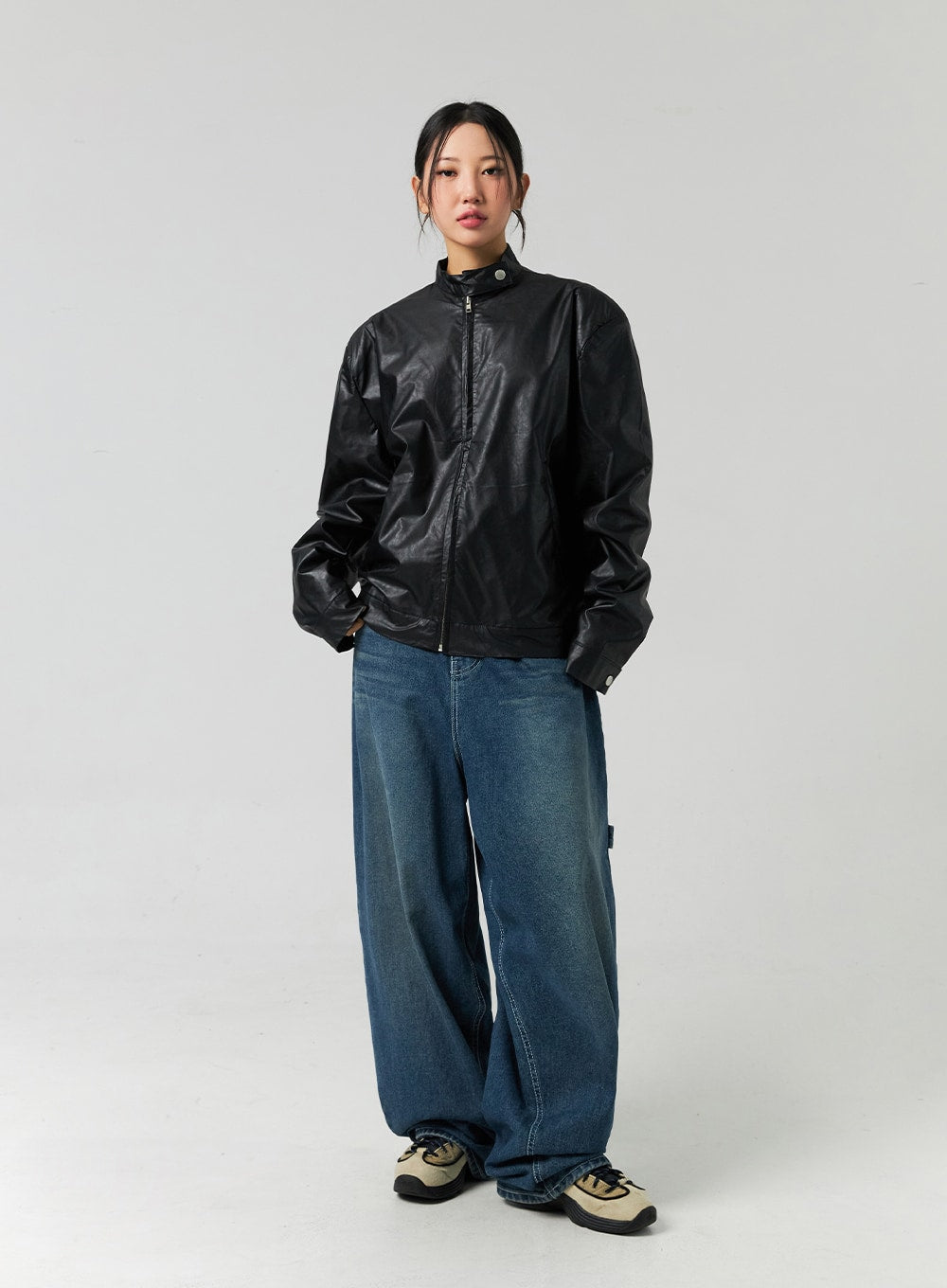 Washed Cotton Wide Leg Jeans CO323 in blue, full-body front shot on model with zipped black leather jacket, wide leg silhouette with faded wash, paired with chunky sneakers.