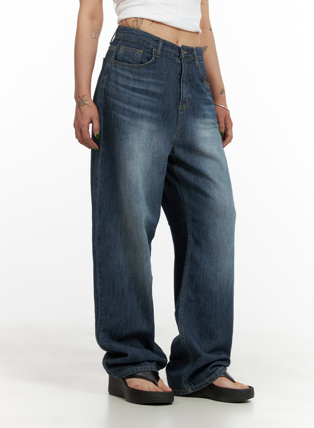 Wide Fit Baggy Jeans CY430 in dark blue, side view on model, washed cotton denim showing wide-leg volume and subtle fading, paired with white crop top and black sandals.
