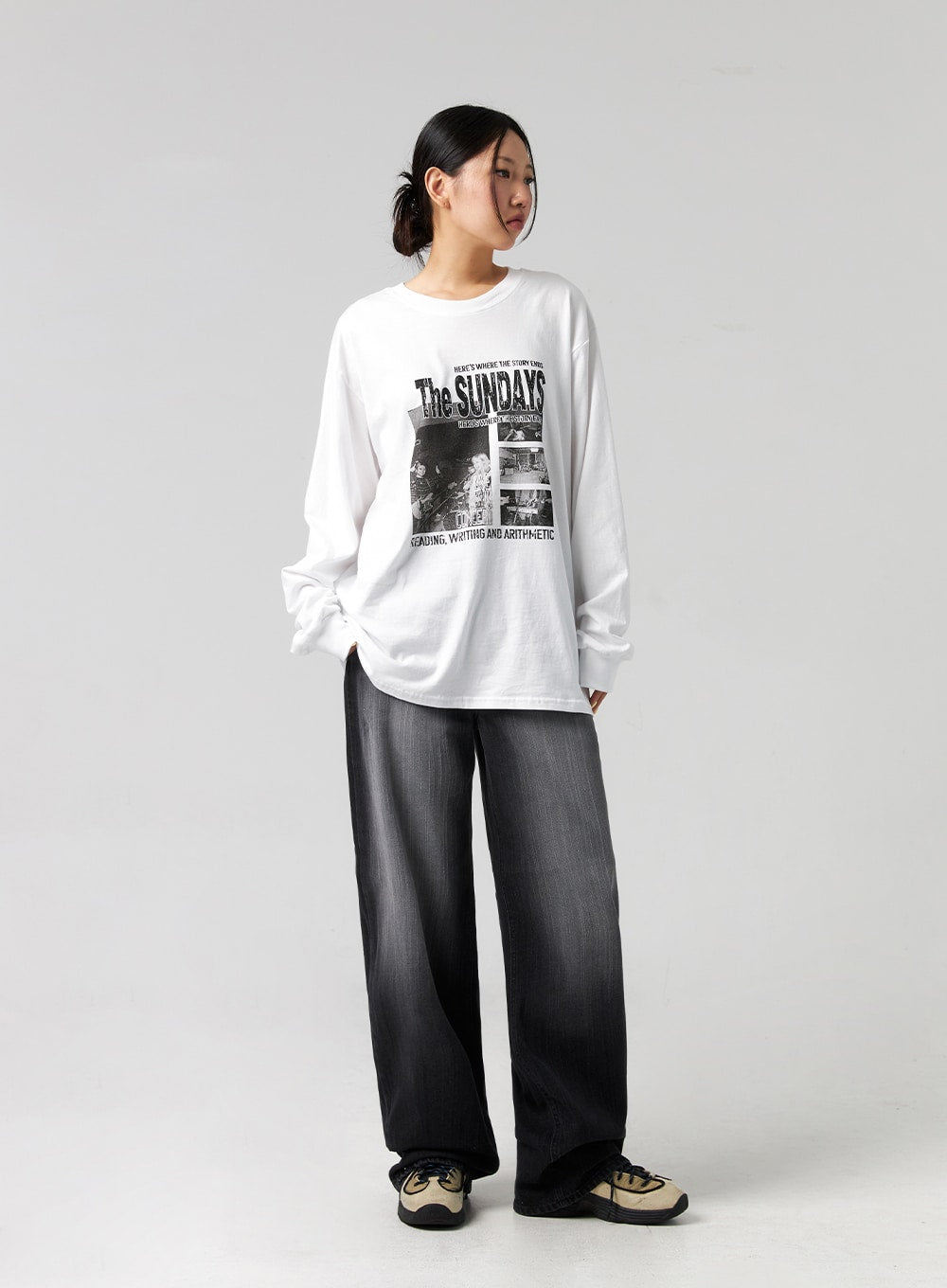Washed Wide-Leg Jeans CG327 in black, full-body side-angled shot on model looking away, relaxed wide-leg denim with washed finish, paired with oversized graphic long-sleeve and chunky sneakers.