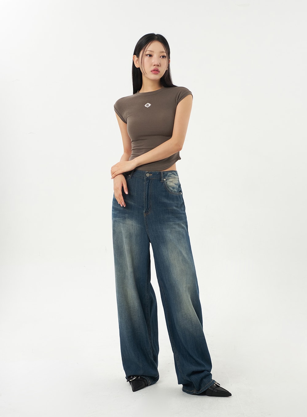 Baggy Low Rise Jeans CA326 in dark blue, full-length front view on model, relaxed wide-leg silhouette with faded wash, low rise waist, styled with brown fitted top.