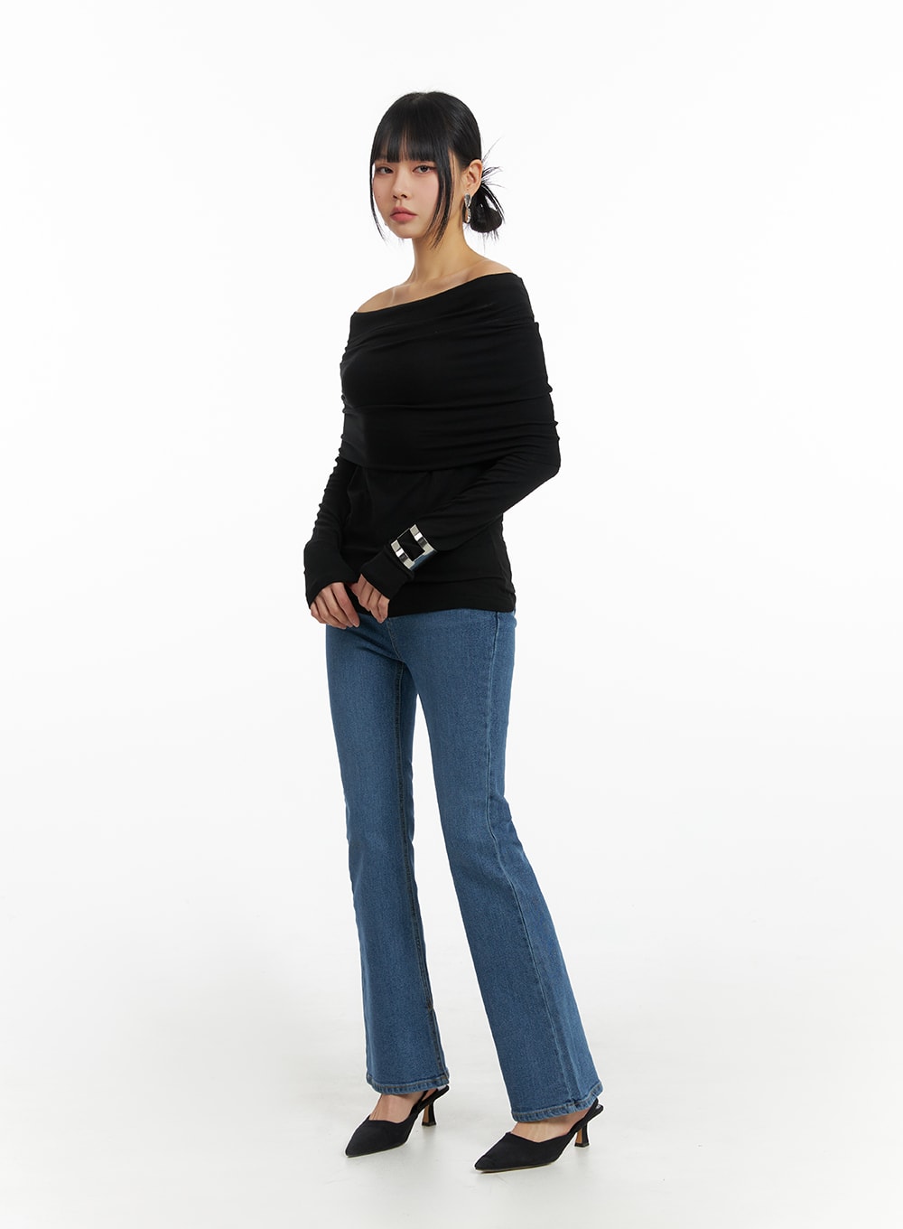 Vintage Flared Jeans IM414 in blue, three-quarter front angle on model, slim-fit washed denim flare silhouette, styled with black off-shoulder long-sleeve top and heels.