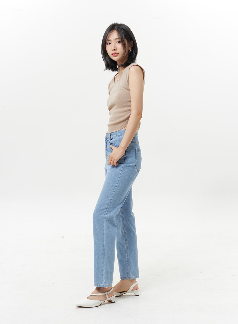 High Waist Jeans OY330 in light blue, side profile model shot, showcasing straight leg line and high waist rise, paired with beige sleeveless top and white mules.