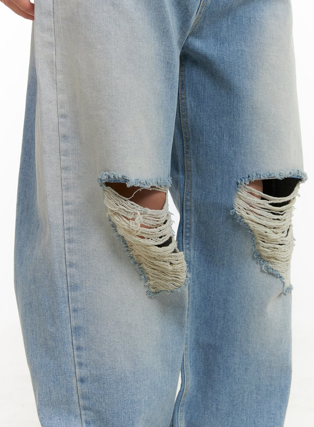 Urban Washed Ripped Baggy Jeans CU405 in Blue, close-up detail of both knee cutouts, showing heavily frayed destroyed denim edges and raw threading on washed cotton fabric.