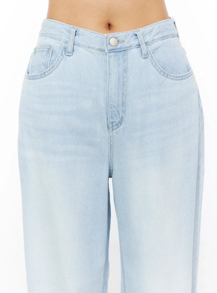 Rina Washed Wide-Leg Jeans CU522 in light blue, close-up front detail on model, showing waistband, button fly, and 5-pocket construction with washed denim texture.