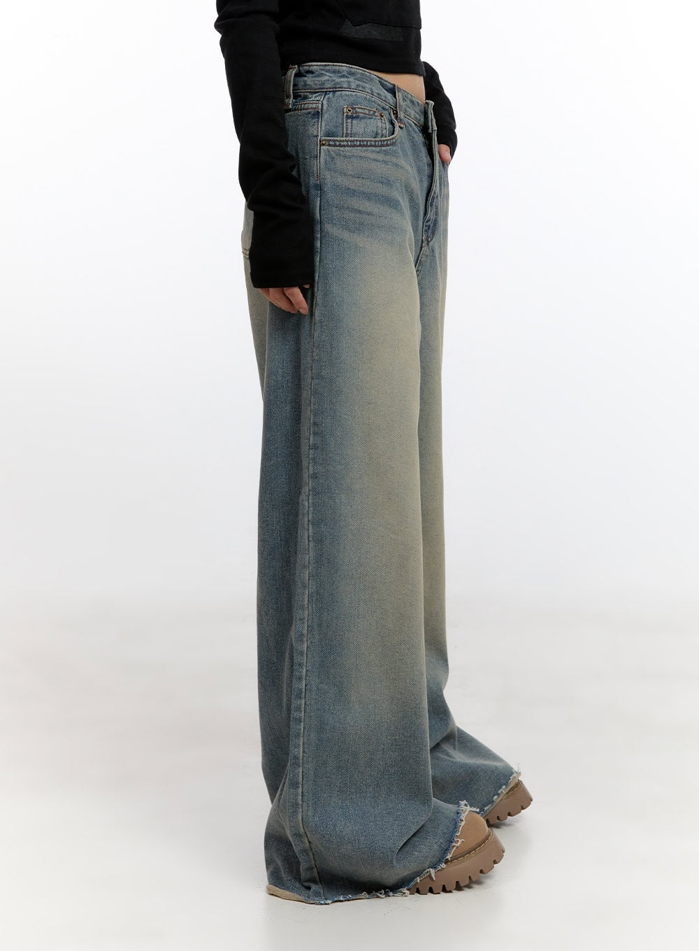 Felicia Cotton Wide Fit Baggy Jeans CN425 in blue, side view on model, washed cotton denim, extreme wide-leg silhouette, raw frayed hem dragging at ground, paired with black long-sleeve top.