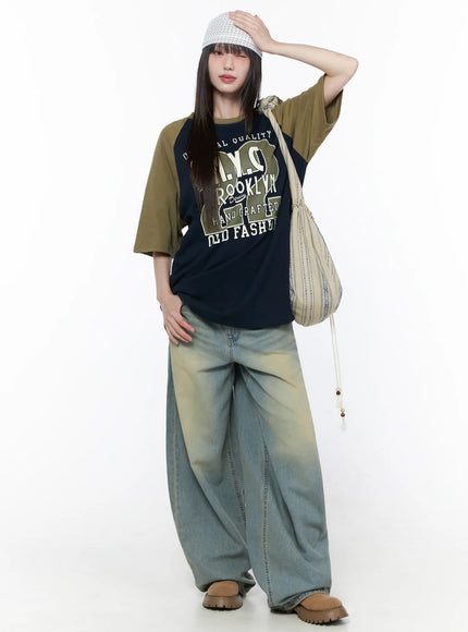 Polka Dot Head Scarf CU519 in White, full-body front shot on model shielding eyes with one hand, scarf tied at back, styled with oversized graphic tee, baggy washed jeans, and chunky loafers.