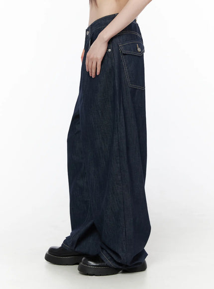 Rowen Baggy Jeans CU519 in dark blue, side view on model, showing exaggerated balloon wide-leg shape, contrast topstitching, flap back pocket detail, worn with black chunky shoes.