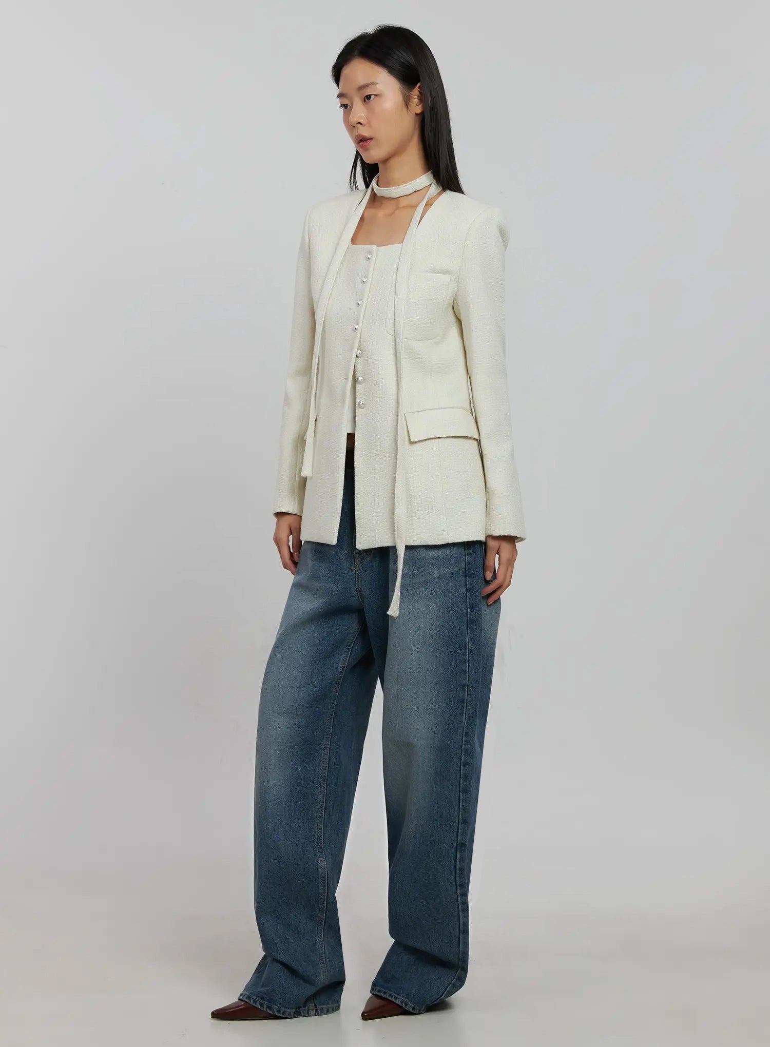 Akira Wide Leg Jeans IJ508 in blue, three-quarter side view on model, long washed wide leg silhouette, paired with open cream tweed jacket and white cami.