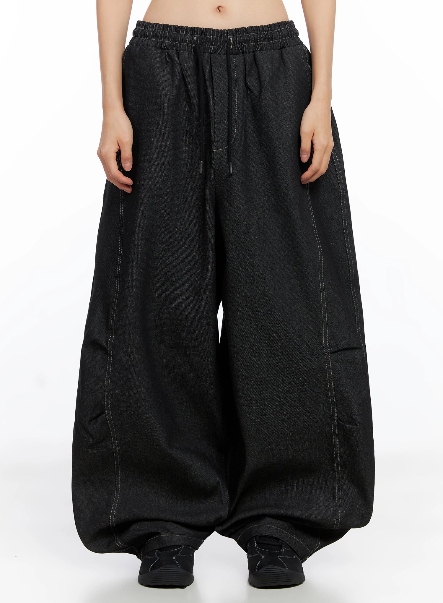 Ayra Graphic Baggy Jeans IO516 in Black, front product shot on model, extreme wide-leg balloon silhouette, elastic drawstring waistband, contrast topstitching, pooling at floor.