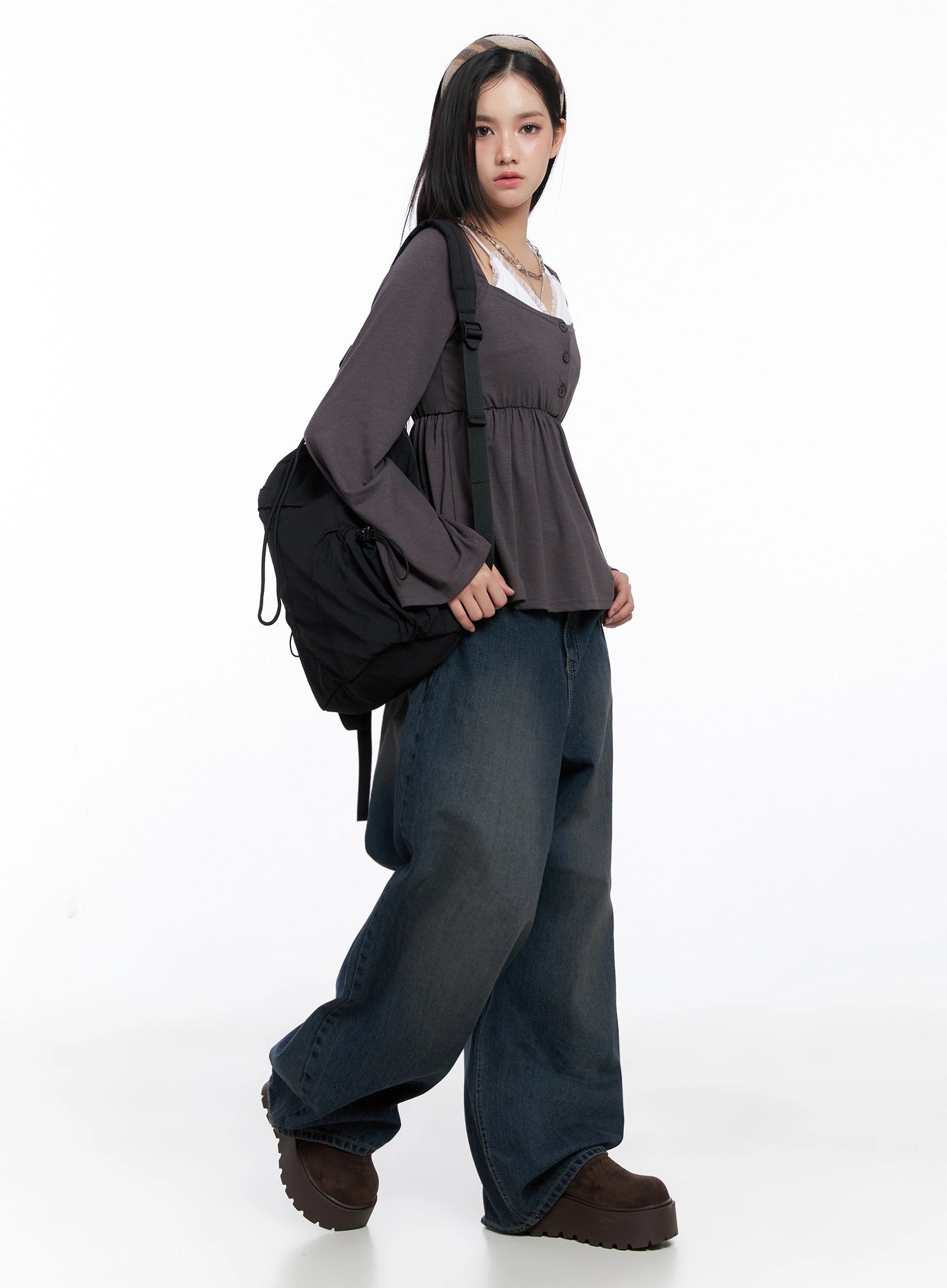 Adelyn Washed Baggy Jeans IS525 in dark blue, side angle full-body shot on model, oversize wide-leg washed cotton denim styled with charcoal peplum long-sleeve and black backpack.