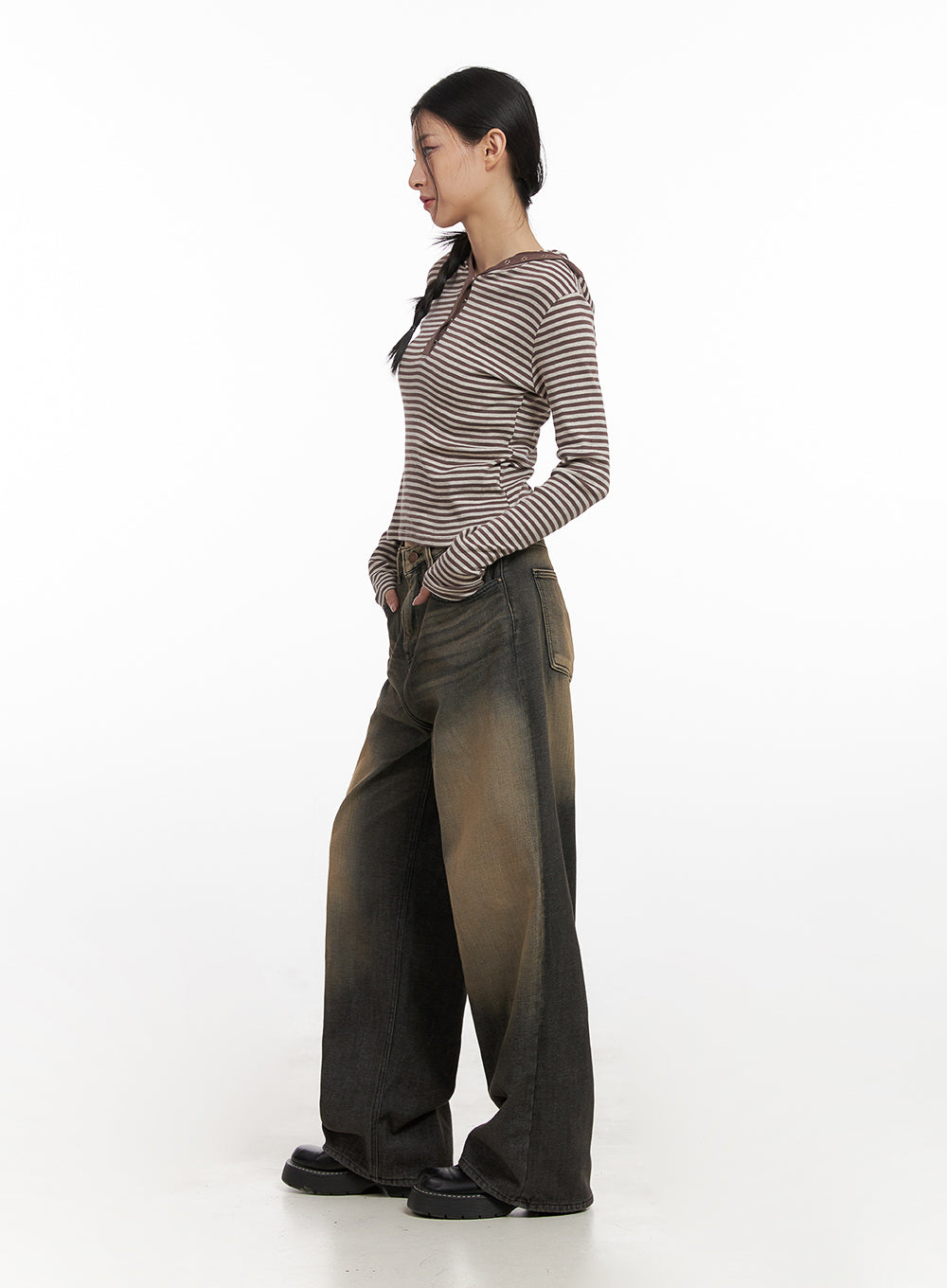 Alexa ComfyChic Washed Jeans CN428 in dark beige, side view on model, wide baggy leg with amber-to-dark washed gradient denim, hands in pockets, paired with striped long-sleeve top and black loafers.