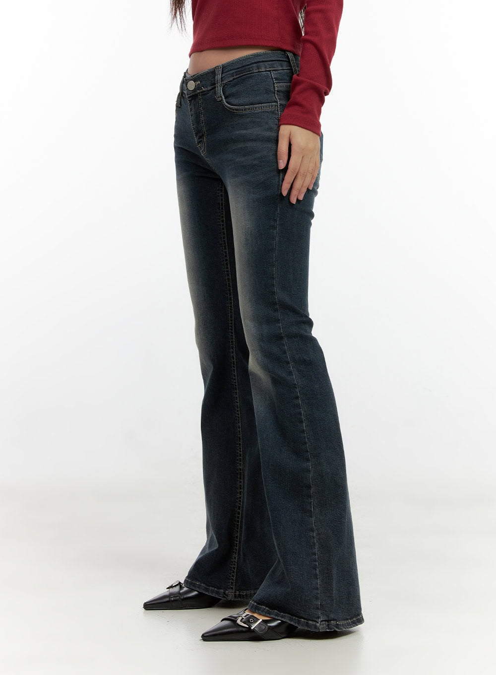 Ingrid Low-Rise Washed Flared Hip Pad Denim Jeans CN404 in dark blue, side view on model, slim thigh to flared bootcut leg, low-rise fit with washed fading, paired with black pointed heels.