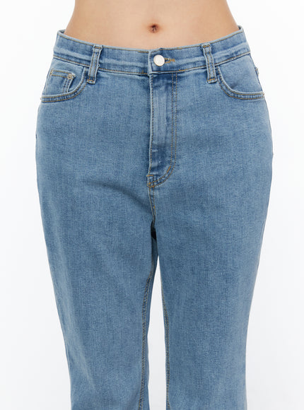 Leana Stretch Bootcut Jeans IU519 in blue, close-up front detail on model, waistband with button closure, 5-pocket construction, contrast topstitching, washed cotton-spandex denim.