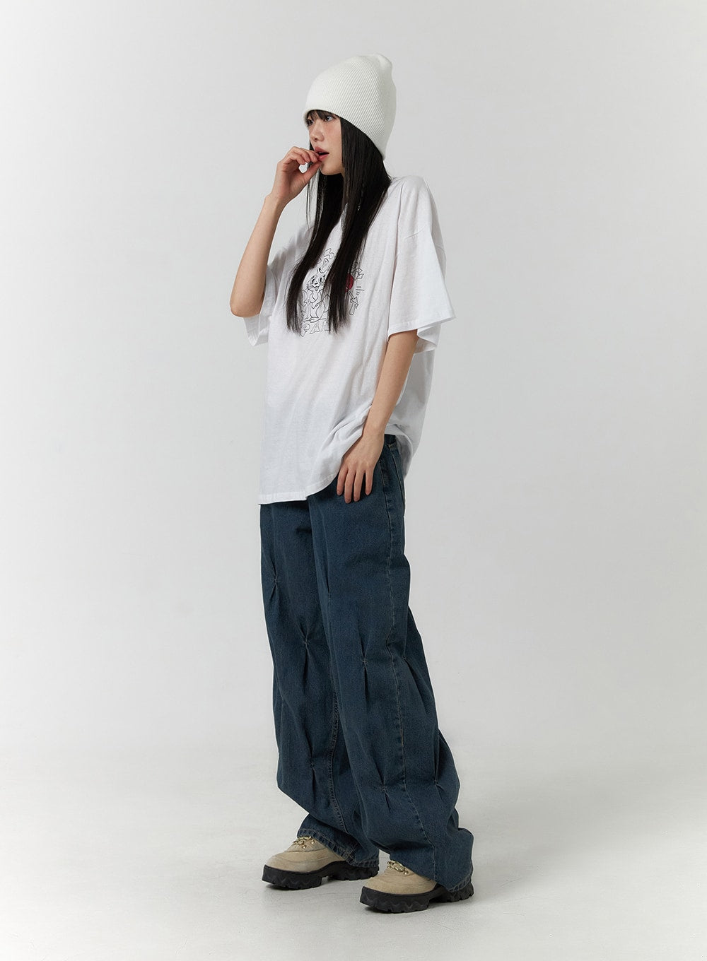 Quilted Wide Leg Denim CF406 in dark blue, three-quarter front-side angle on model, wide-leg washed denim with quilting detail pooling at hem, worn with white tee and white beanie.