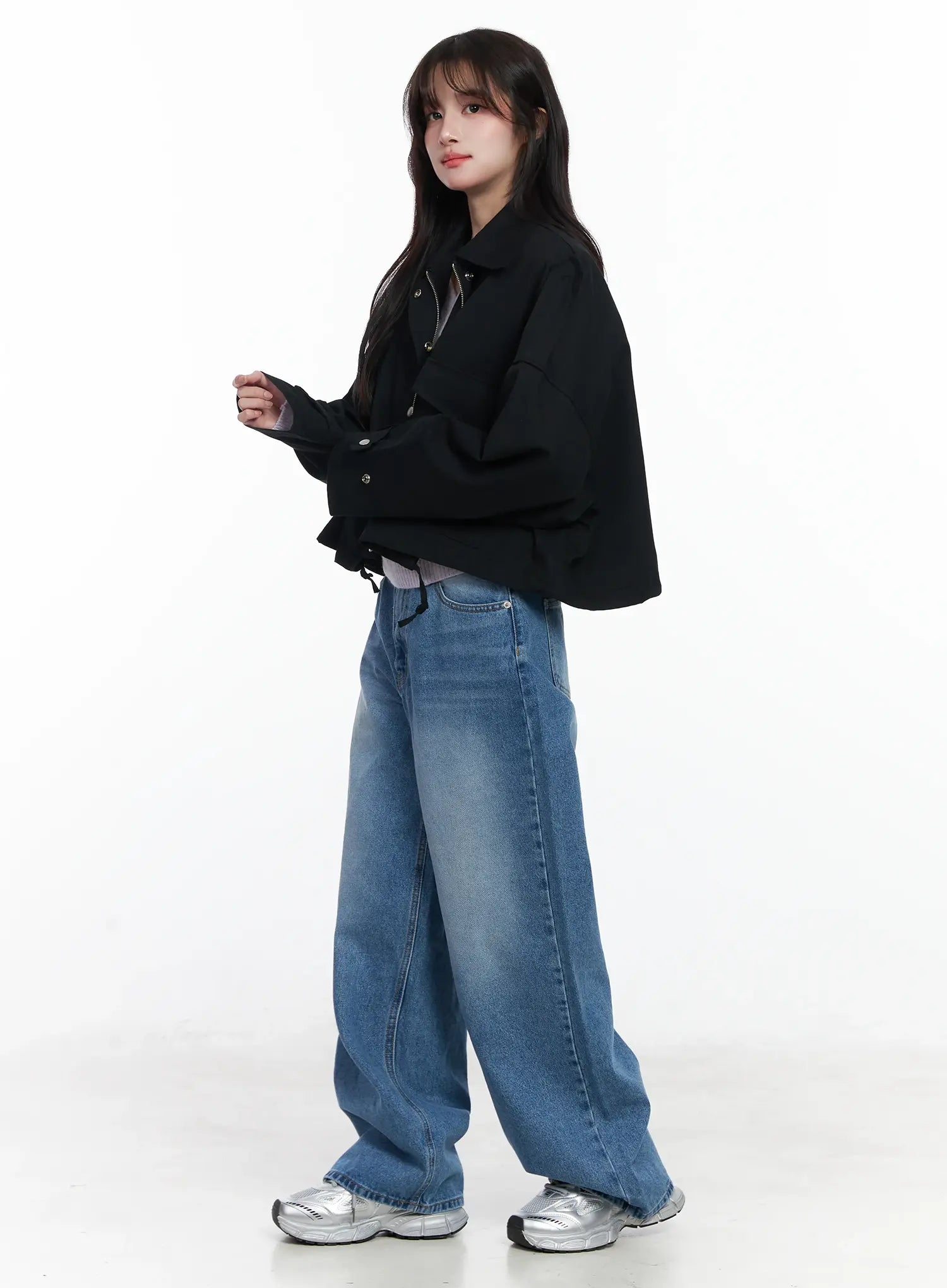 Iliana Wide Leg Jeans IJ529 in blue, side view on model, wide baggy washed cotton denim with relaxed silhouette, styled with black cropped jacket and silver sneakers.
