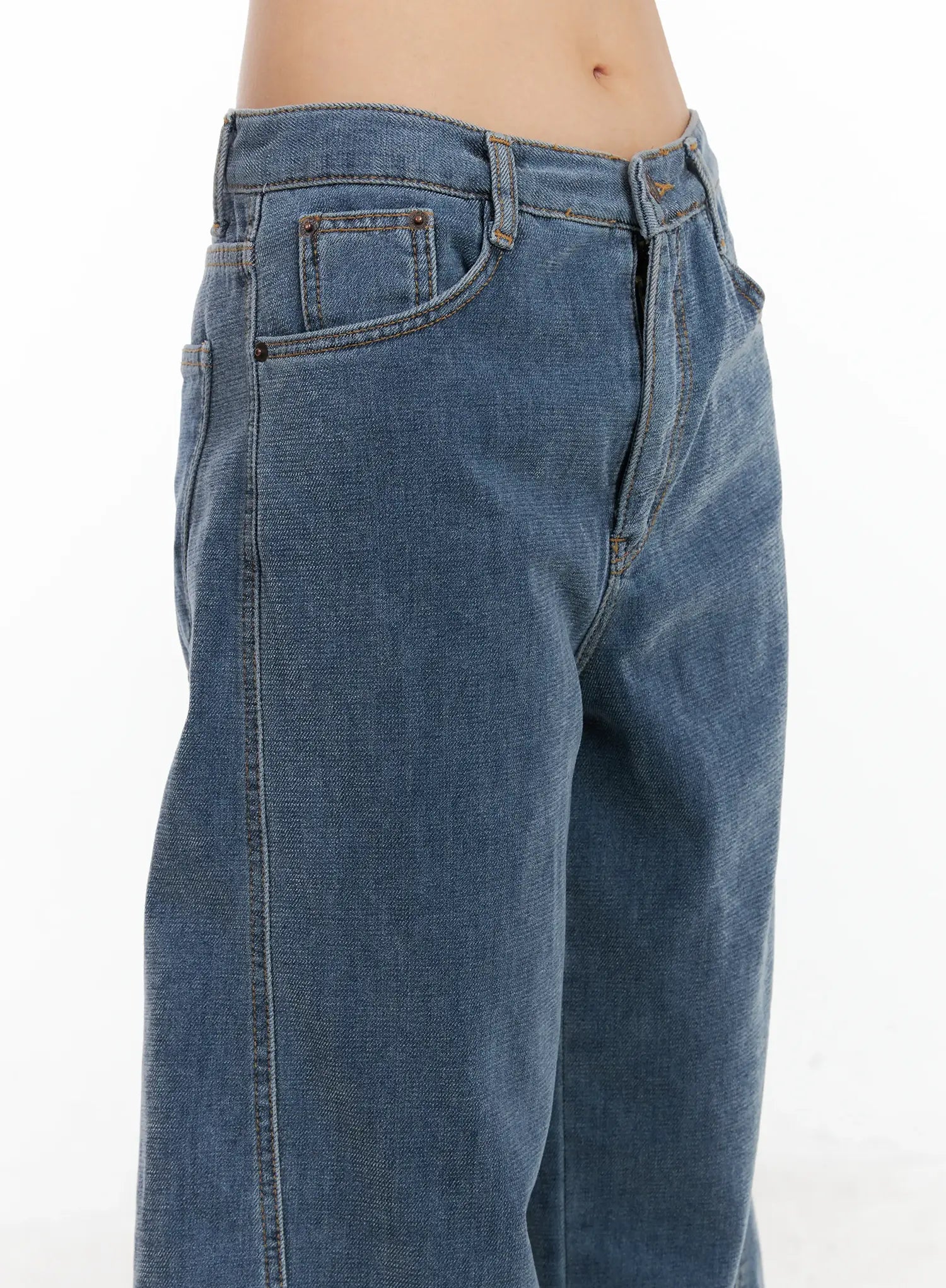 Norah Oversized Jeans CN528 in blue, side close-up on model showing waistband, front pockets, copper rivets, and washed denim texture detail.