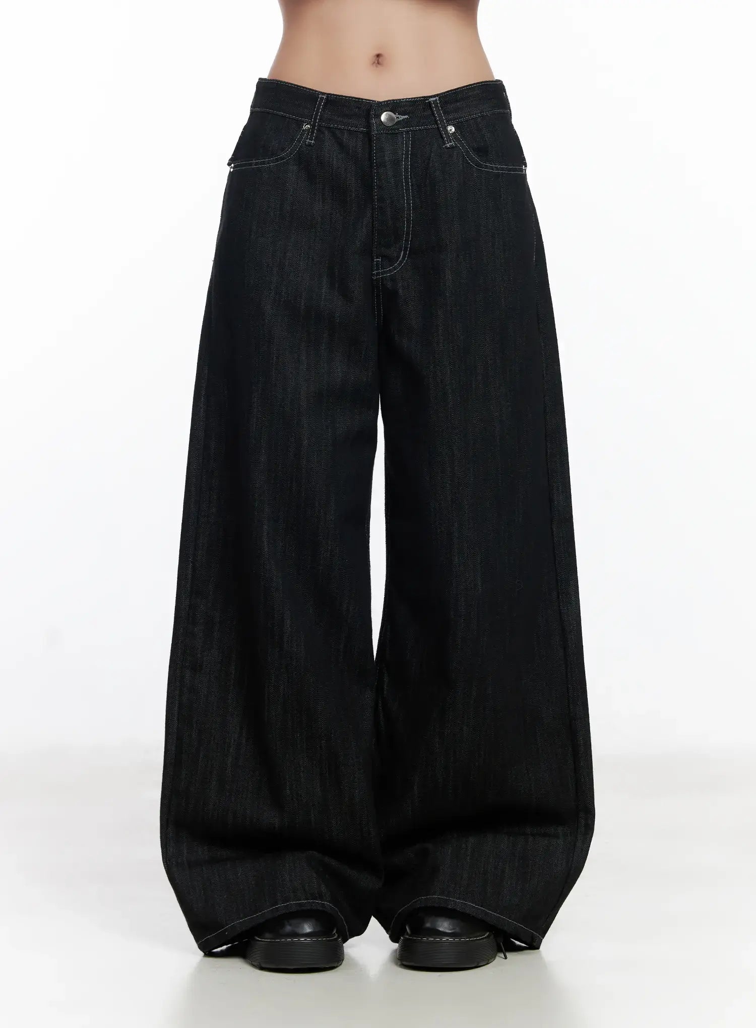 Violet Studded Baggy Jeans CJ530 in black, front close-up on model, low-rise wide-leg cotton denim with contrast white stitching and silver button, ultra-baggy leg hem pooling at black loafers.