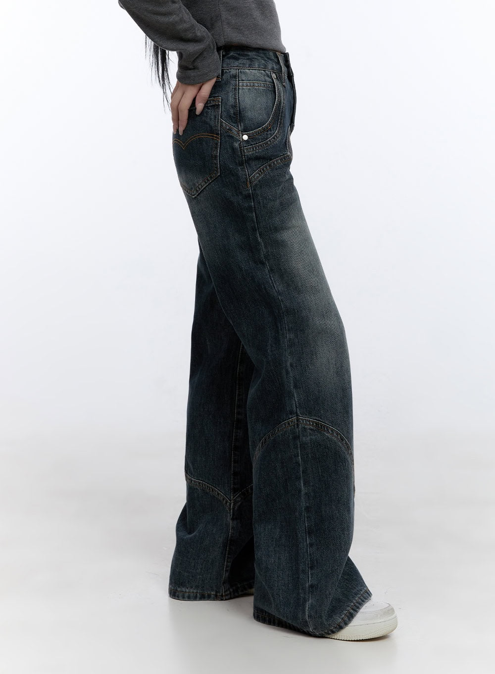 Barbara Washed Wide Leg Jeans CD420 in blue, side view on model, washed cotton denim showing curved panel seams and wide leg hem, hand in back pocket, paired with grey top and white sneakers.