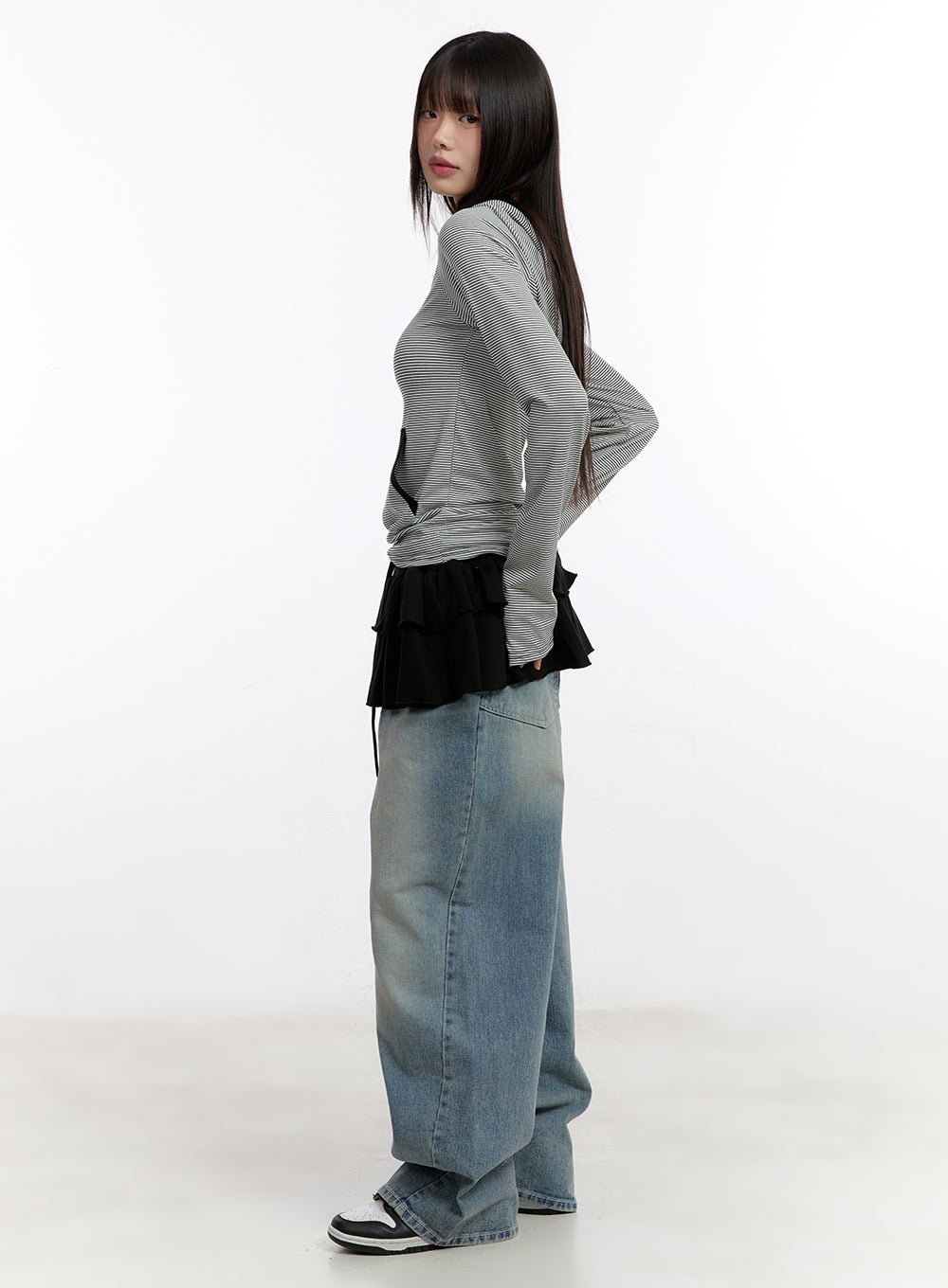Jillie Washed Baggy Jeans CA508 in blue, side profile full-length view on model, wide-leg washed denim with faded wash, paired with striped hoodie and ruffle mini skirt layer.