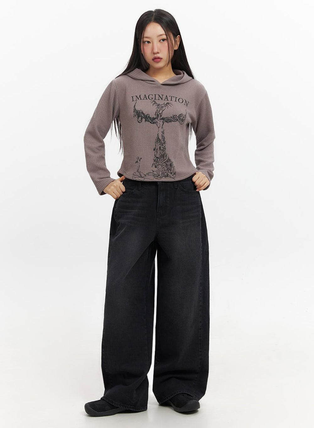 Ashly Wide-Leg Jeans IF511 in washed black, front three-quarter on model with hands on waistband, loose wide-leg silhouette, styled with cropped graphic hoodie and belt.