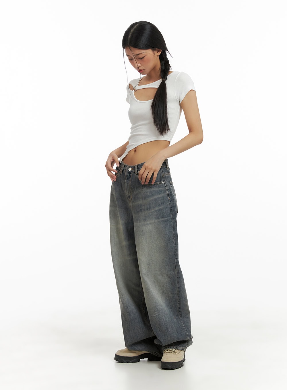 Vintage Washed Baggy Jeans CA424 in blue, full-body side view on model looking down, wide-fit denim with heavy vintage wash, low rise waist, voluminous leg, paired with white crop top.
