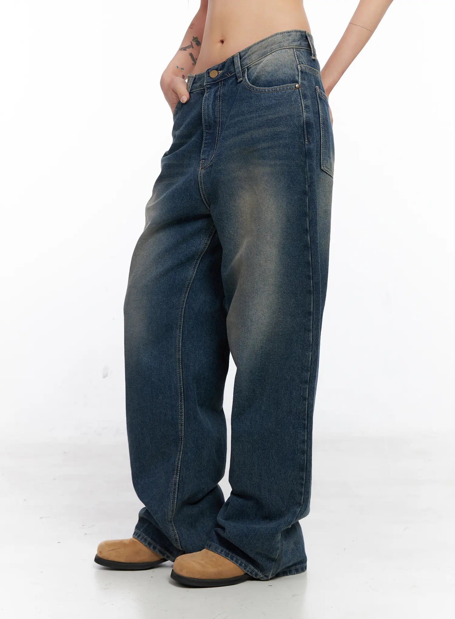 Xyla Vintage Pocket Baggy Jeans CO507 in blue, side view on model, loose-fit washed cotton denim showing wide leg silhouette and faded wash, with tan boots.