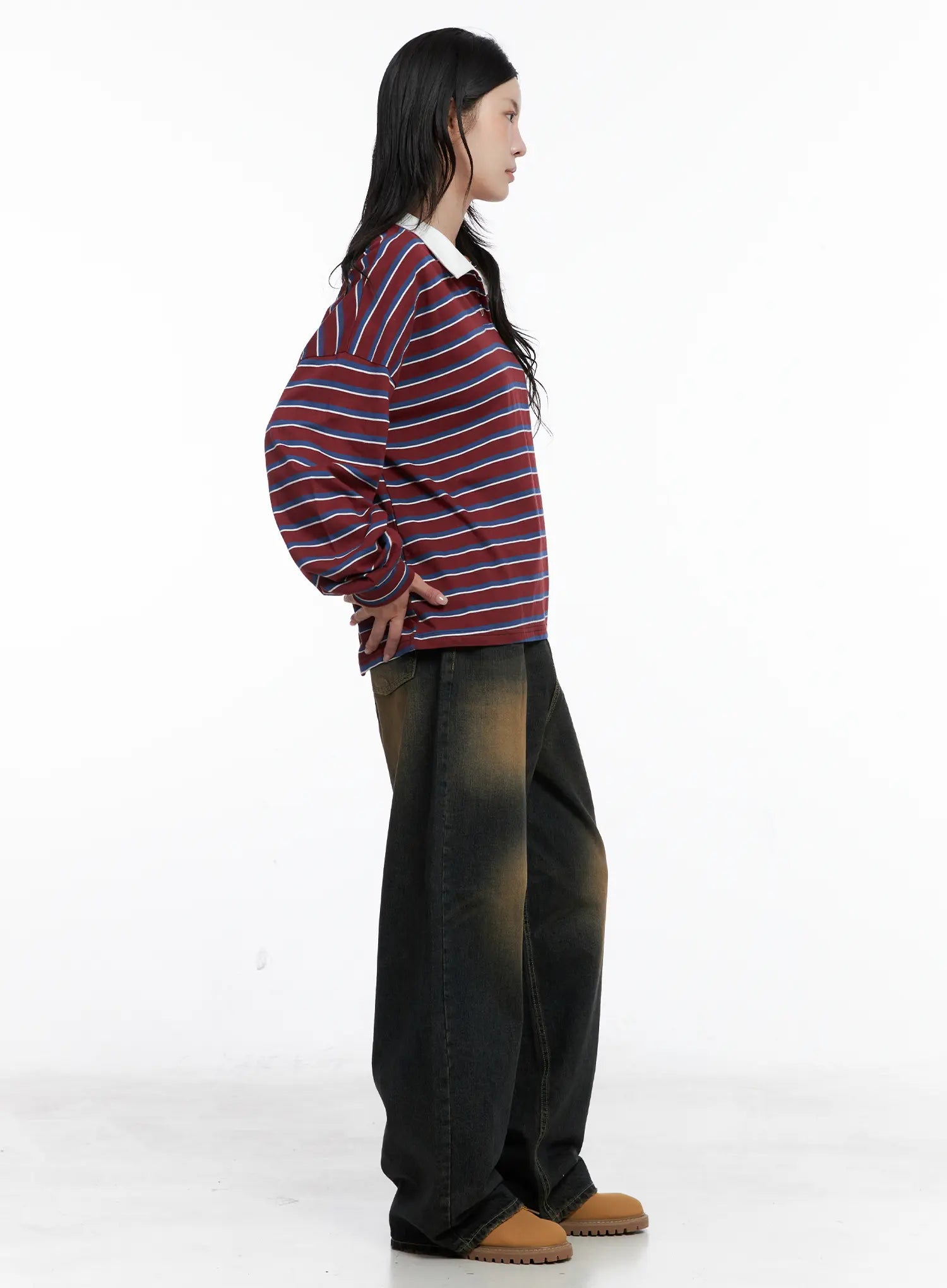 Leona Vintage Baggy Jeans CS526 in dark blue, side view on model, wide-leg silhouette with amber faded wash and relaxed drape, paired with striped polo and tan boots.