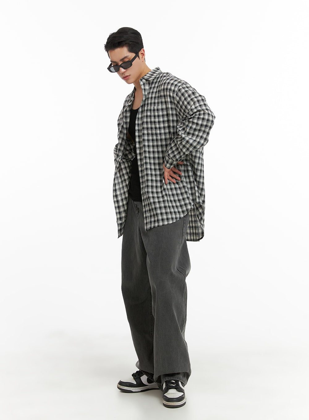 Men's Classic Baggy Fit Jeans IA401 in washed grey, three-quarter side-angled shot on model looking down, relaxed wide leg, styled with open plaid shirt over black tank.