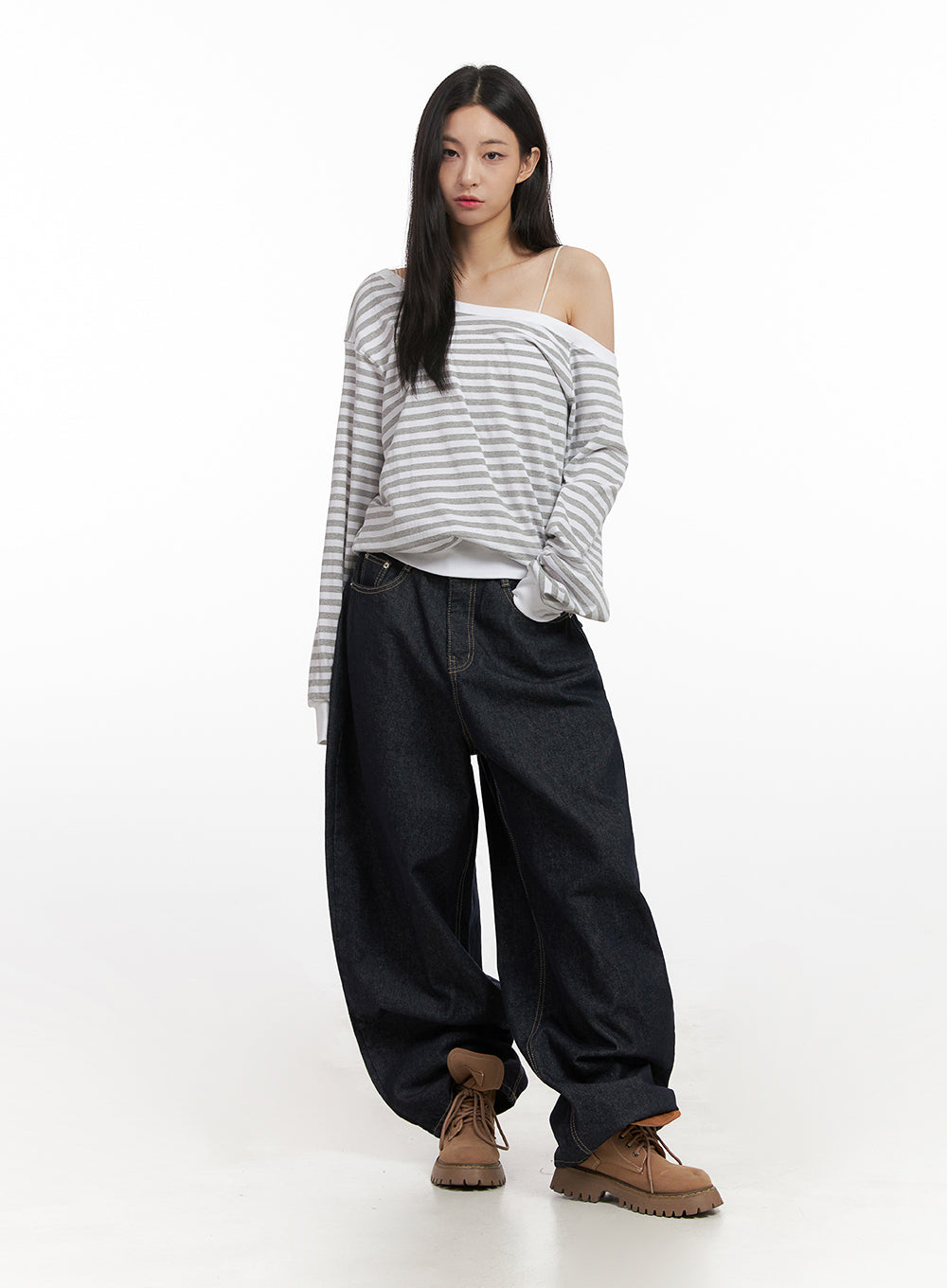 Lily Stitched Wide-Leg Jeans CN426 in dark blue, full-length front shot on model, voluminous wide-leg cotton denim, hands in pockets, paired with asymmetric striped top and tan boots.