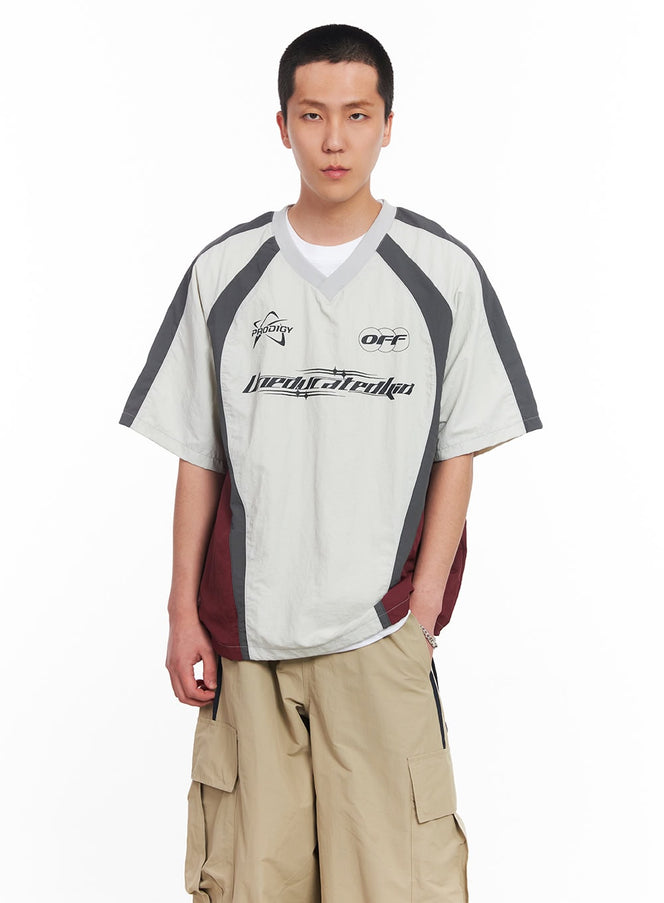 LEWKIN Men's Nylon Graphic V-Neck T-Shirt IU512 in light grey, front torso shot on model, racing-style colorblock nylon with grey and burgundy panels, graphic print, paired with khaki cargo pants.