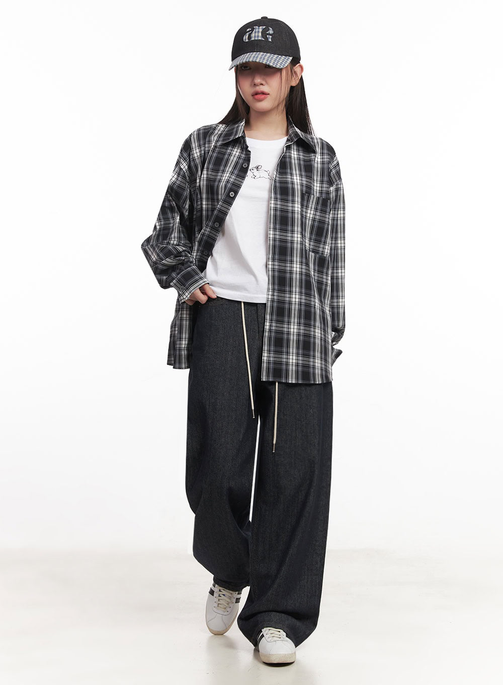 Kirsten String Wide-Leg Summer Denim Jeans IM528 in dark blue, angled front view on model mid-stride, cream drawstring at low waist, styled with open plaid shirt, white tee, and sneakers.