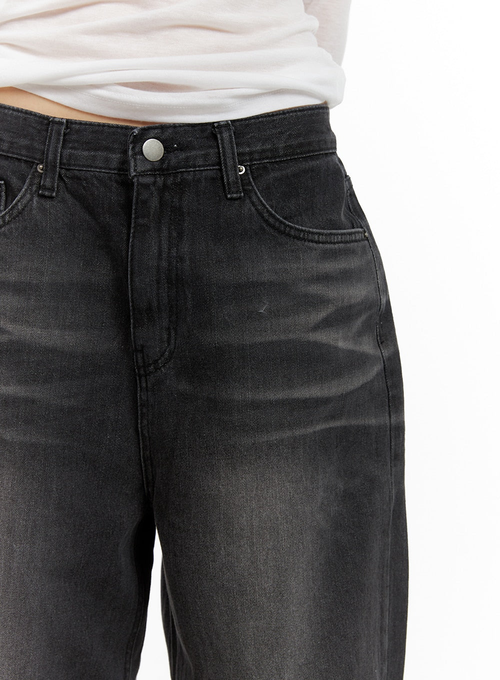 Pintuck Washed Denim Wide Leg Jeans CA419 in black, waist close-up on model, showing silver button closure, front pockets, and faded washed denim texture.
