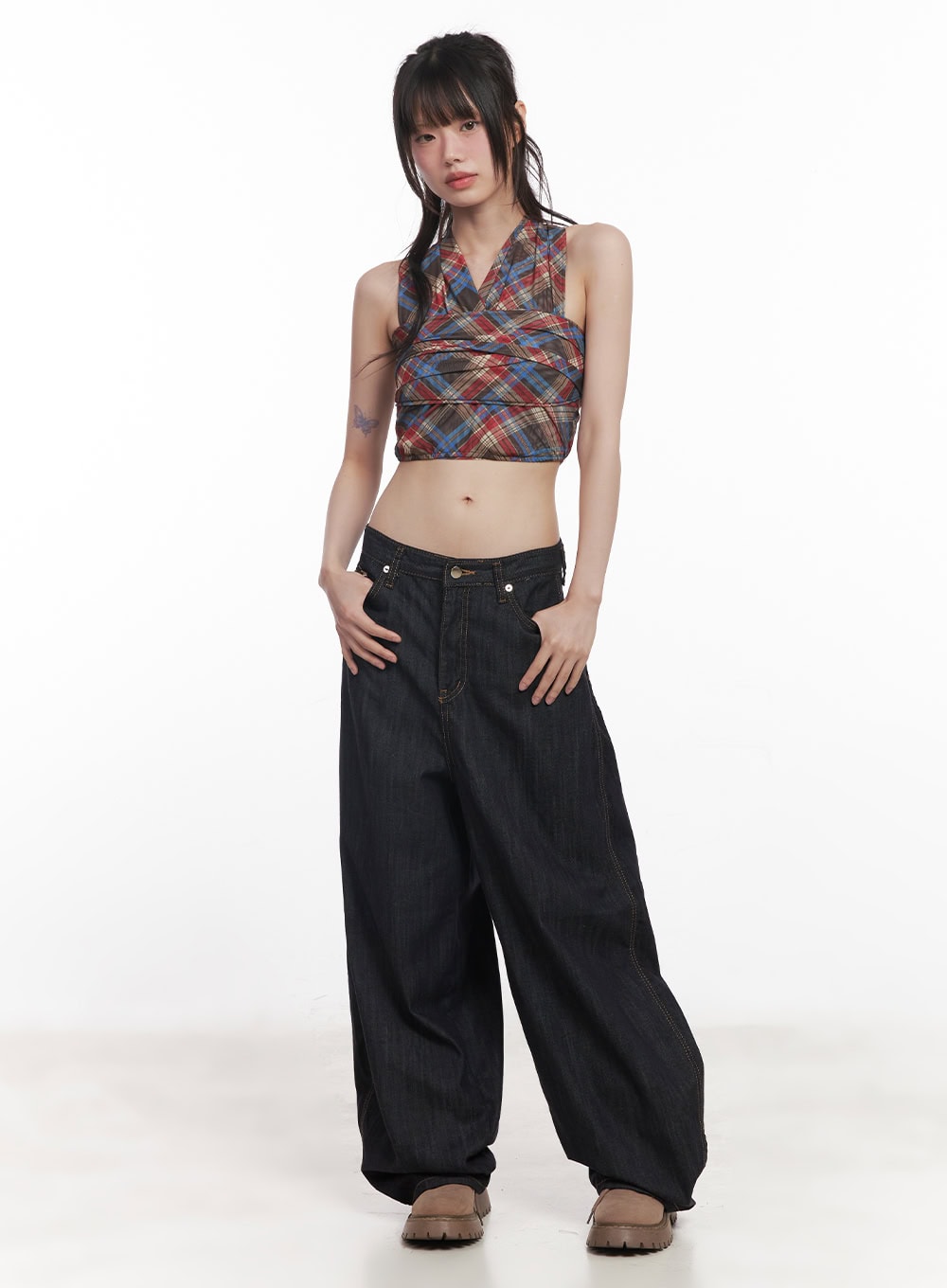 Jessie Stitched Wide-Leg Jeans CY520 in dark blue, front three-quarter view on model, low-rise wide fit denim with contrast stitching, hands in pockets, worn with plaid crop top.
