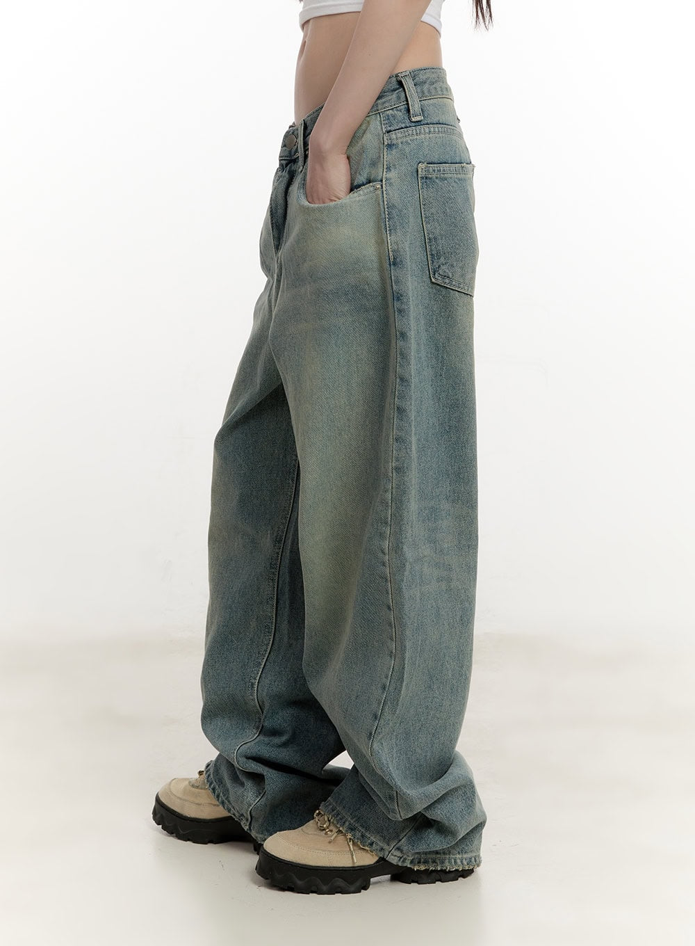 Galinda Washed Baggy Jeans CM513 in vintage blue, side view on model, hand in pocket, ultra-wide leg silhouette with faded wash and raw frayed hem stacking over beige chunky shoes.