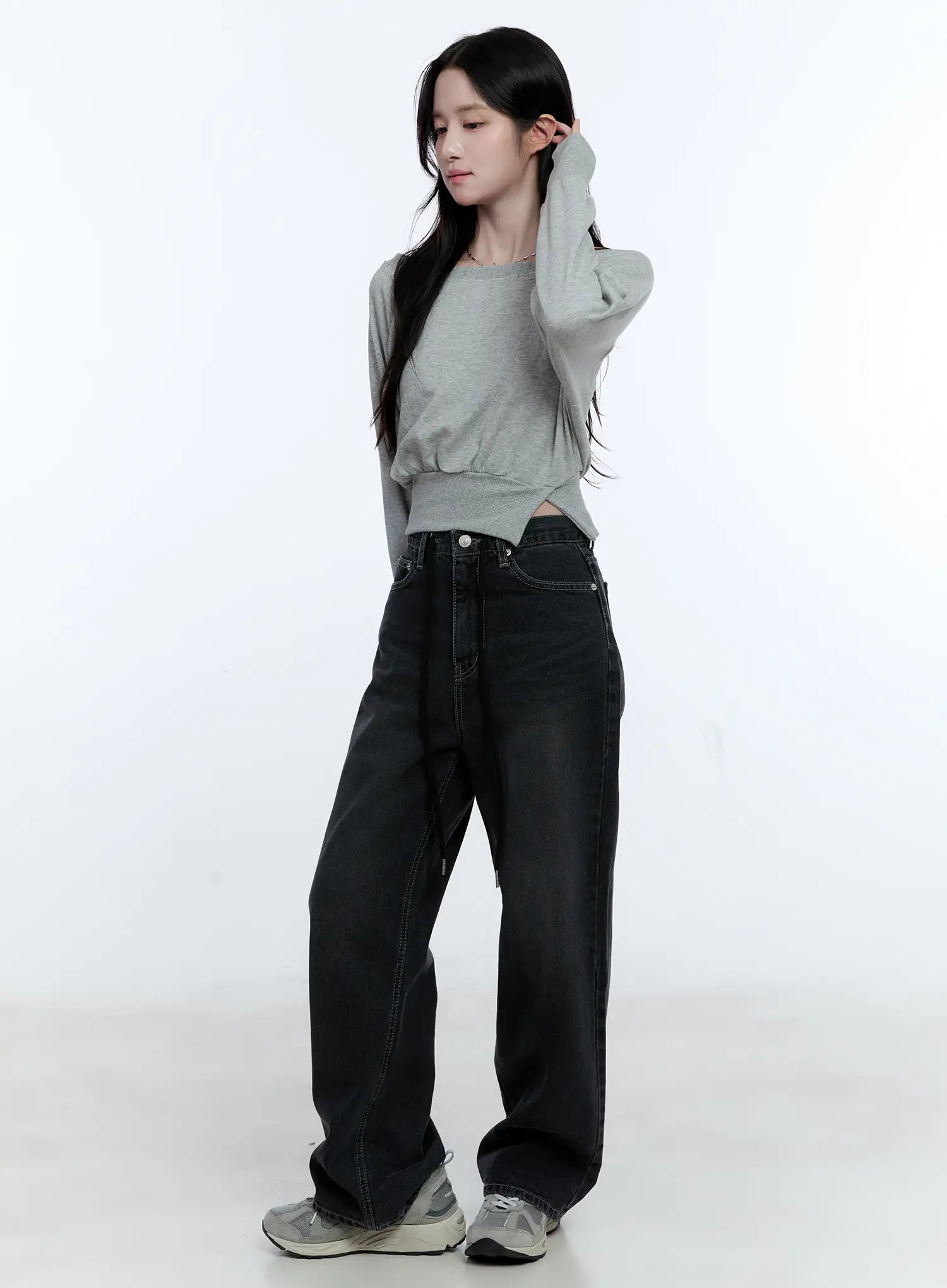 Lucinda High-Rise Wide Leg Jeans CG512 in black, full-body three-quarter front shot on model with hand raised, washed denim wide leg fit, high-rise waistband, paired with gray crop top and sneakers.