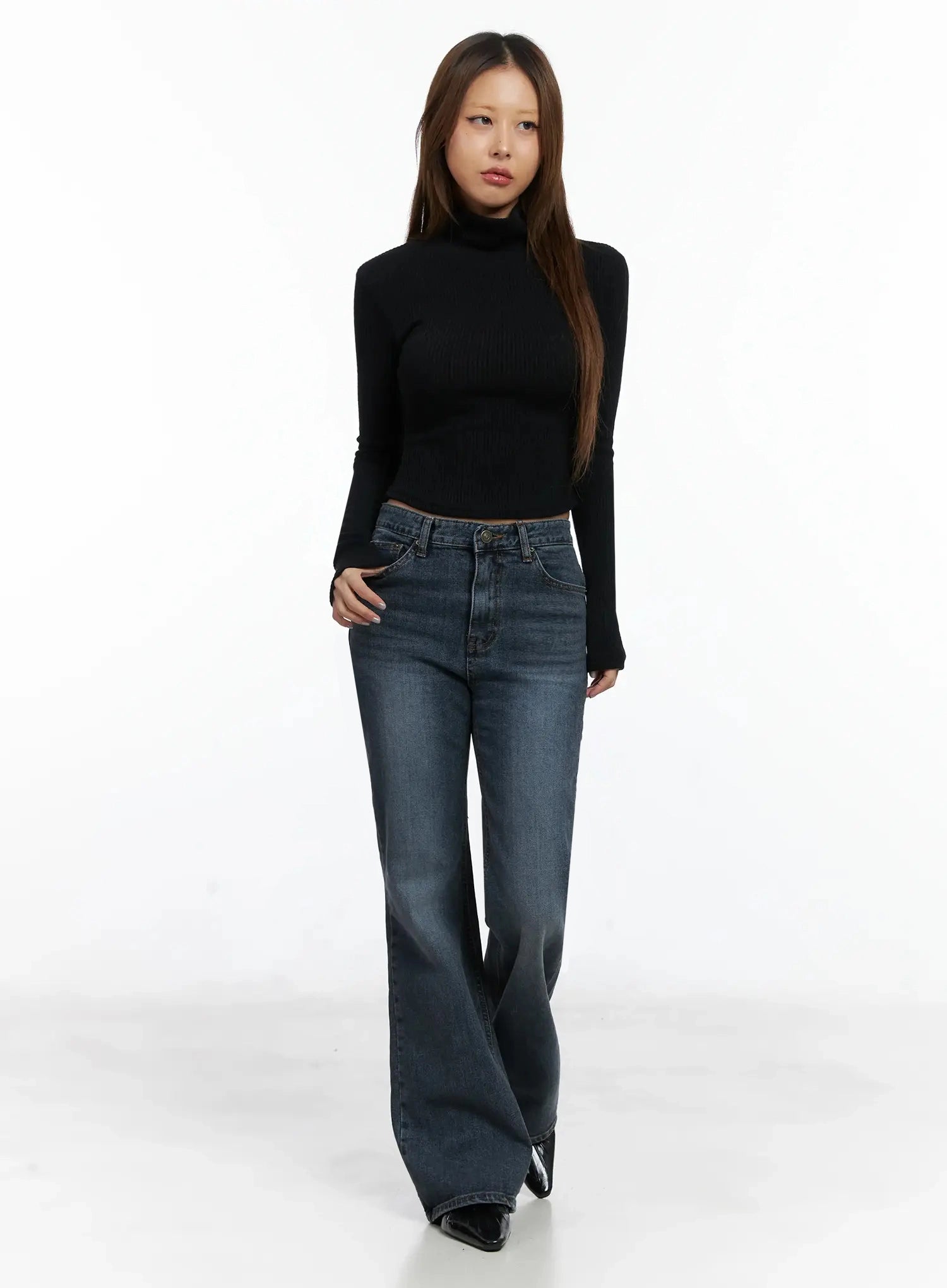 Rara Fleece Flared Jeans ID503 in blue, full-body front view on model, long washed bootcut leg with subtle flare, paired with black ribbed turtleneck crop top and black pointed flats.