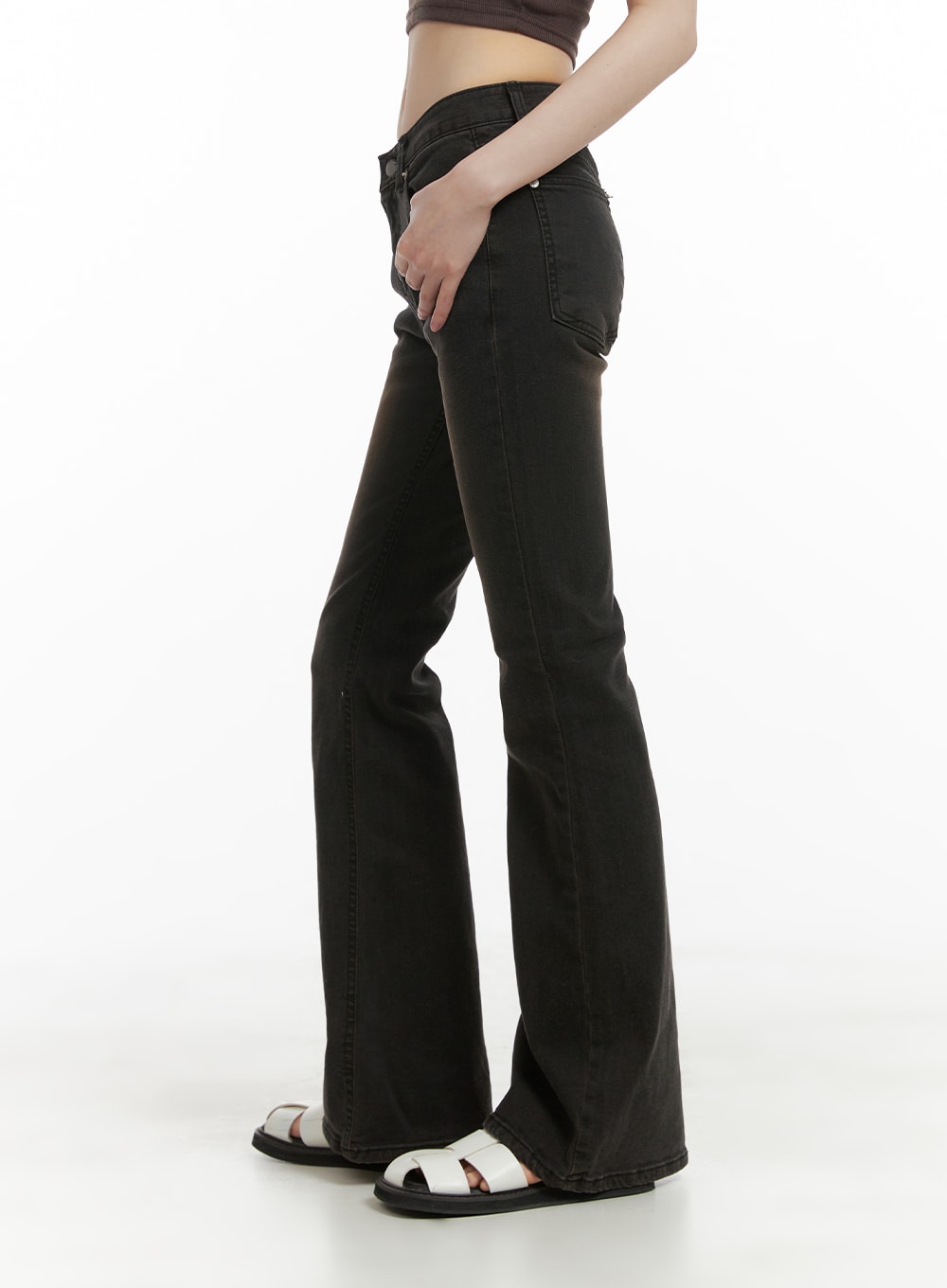 Vintage Washed Bootcut Jeans CA412 in black, side view on model, slim low-rise fit with subtle bootcut flare, washed denim, paired with dark crop top and white sandals.