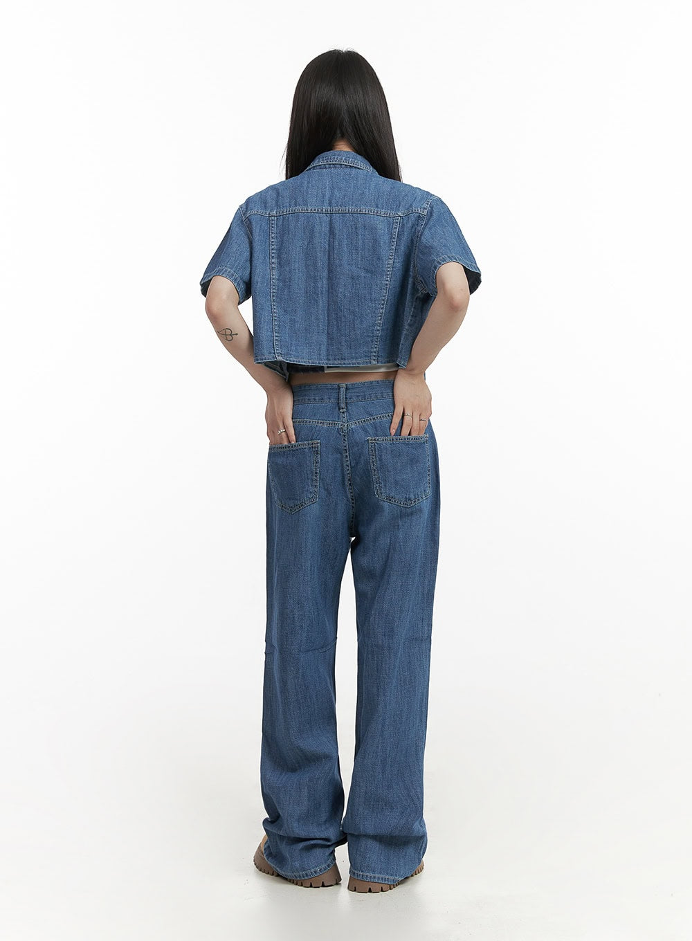 Solid Low Rise Baggy Jeans CY407 in blue, back full-body view on model, showing patch back pockets and wide-leg washed denim, paired with cropped denim jacket and tan boots.