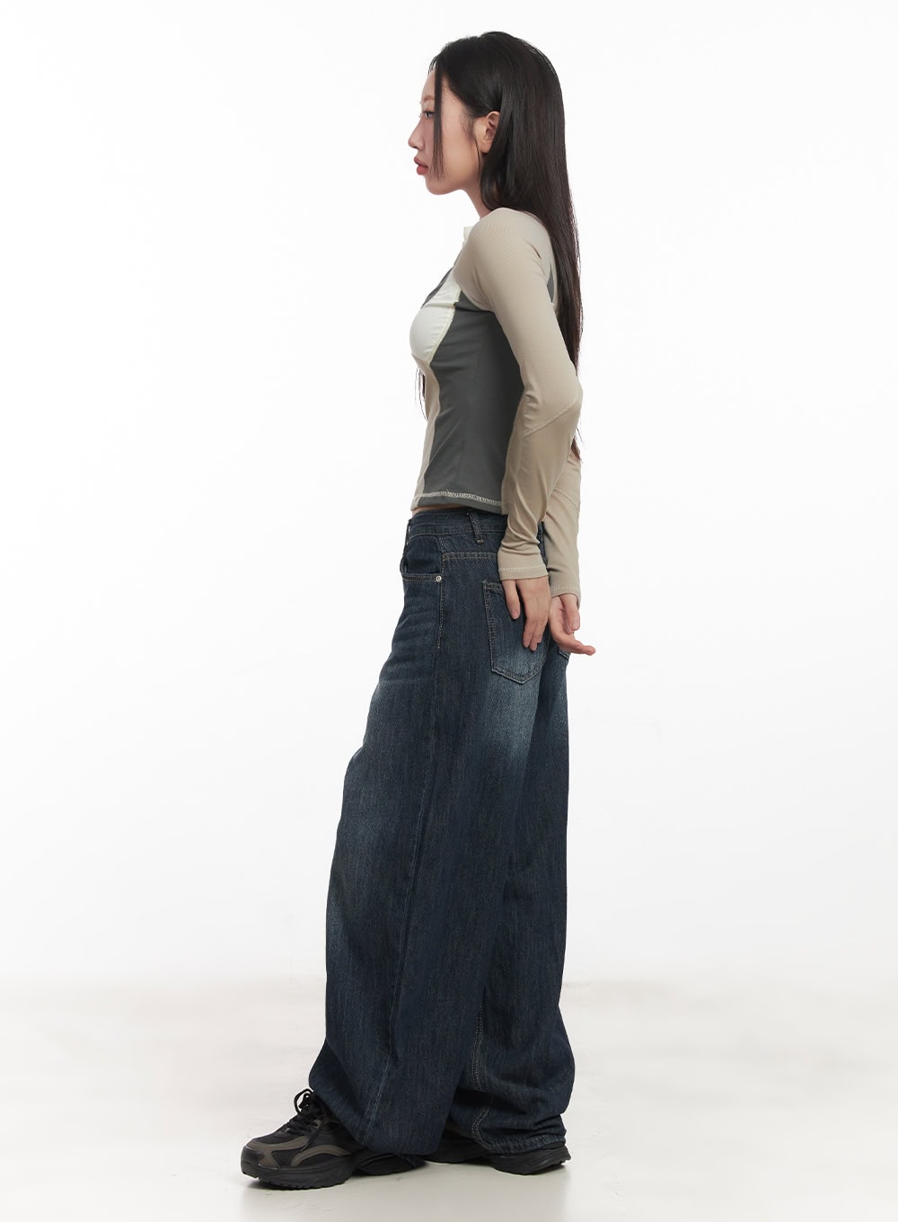 Renna Baggy Jeans CA521 in dark blue, side profile full-length on model, exaggerated wide-leg washed cotton denim, voluminous hem pooling over black chunky sneakers.
