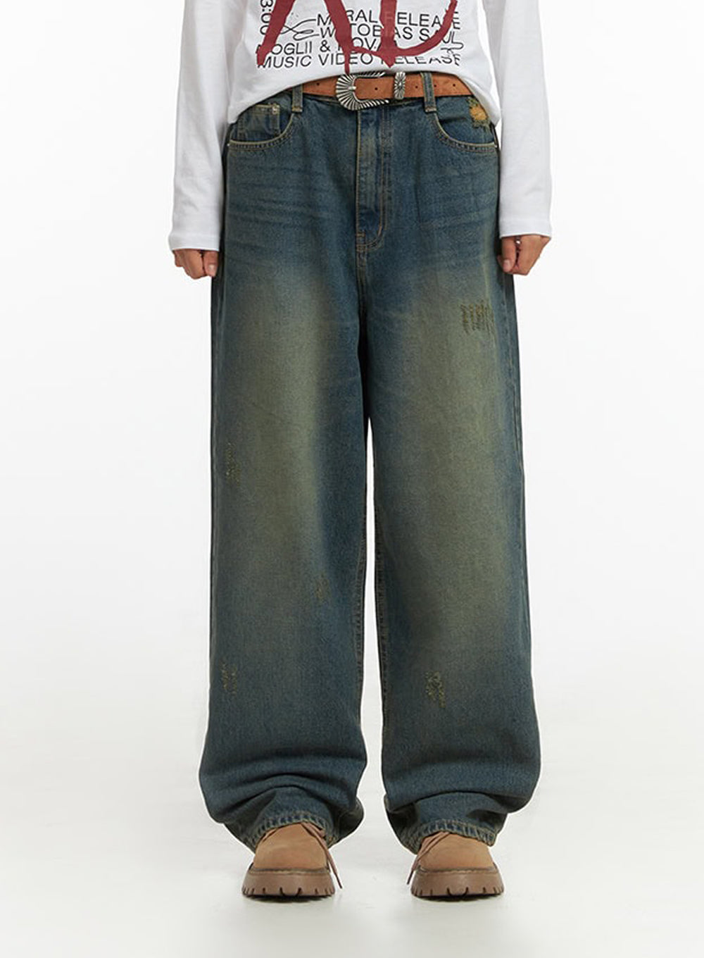 LEWKIN Anya Wide Fit Denim Jeans IO409 in blue 1XL, front cropped view on model, baggy washed cotton denim with yellow-tinted fade, distressed details, paired with graphic tee and brown belt.