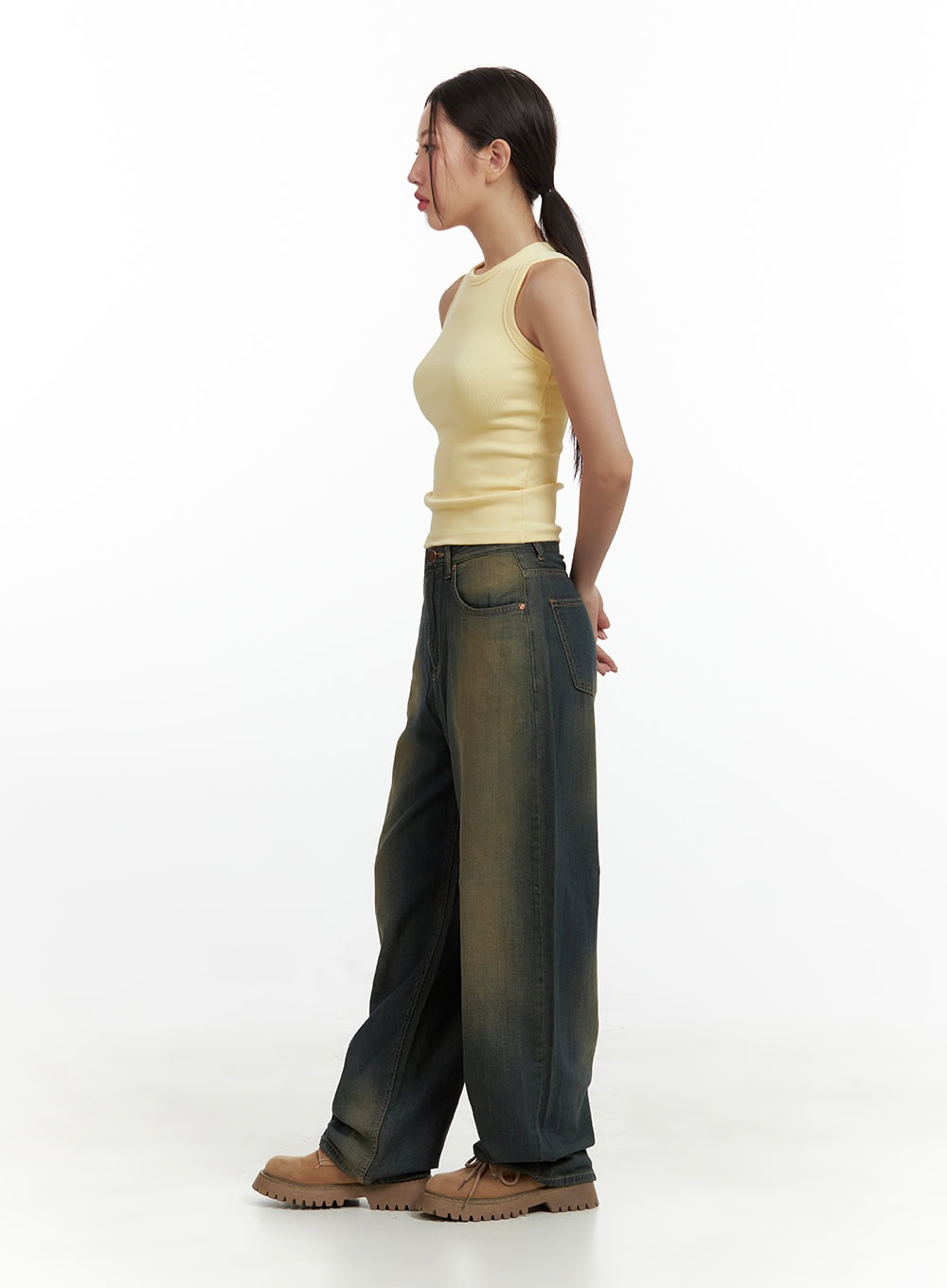 Vintage Washed Denim Baggy Pants CU420 in dark yellow, side view on model, showing relaxed wide-fit length and faded yellow-toned denim, styled with sleeveless top and boots.