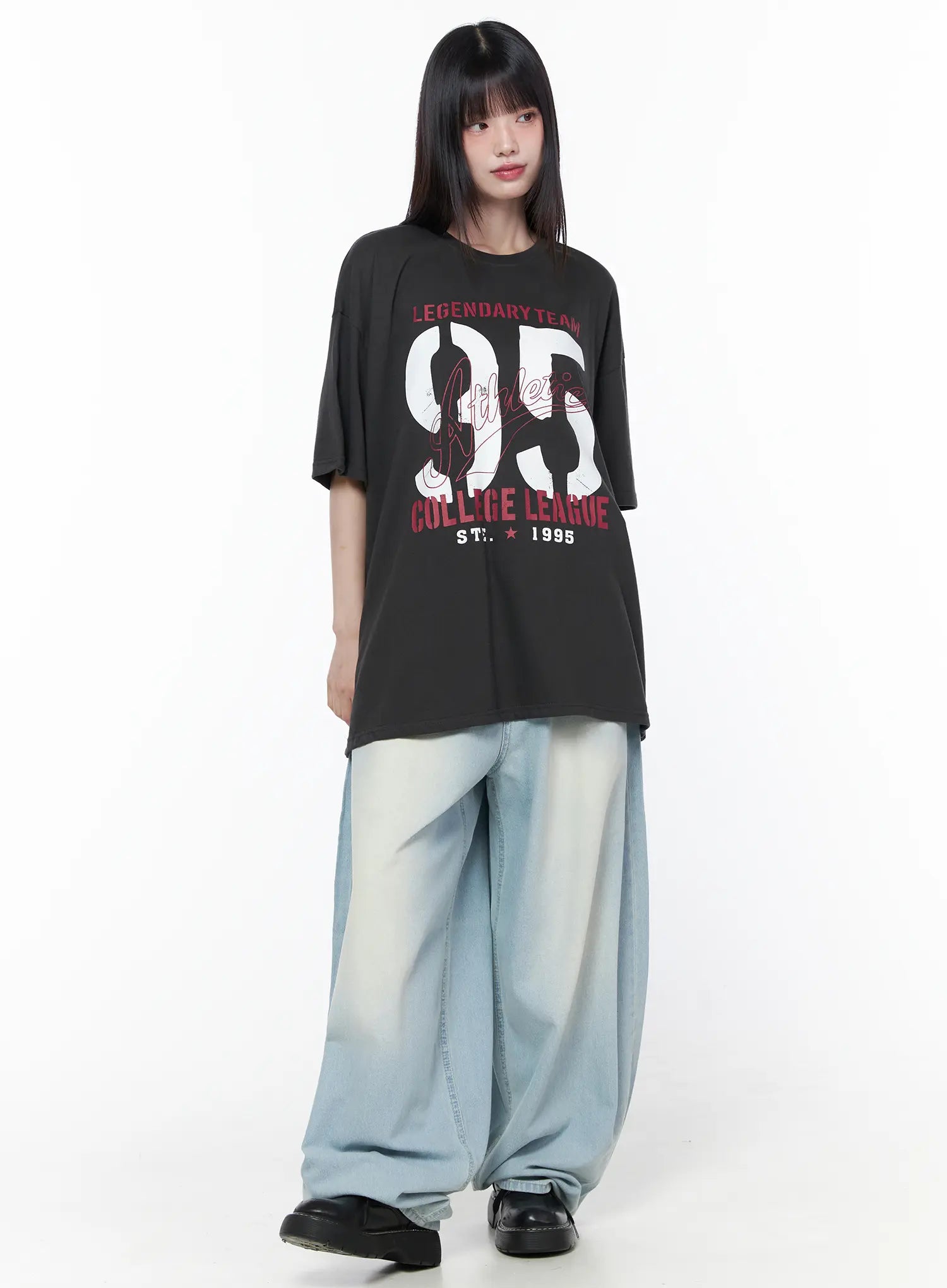 Oversized Graphic Tee CU519 in dark gray, full-length front on model, longline hem, oversized drop-shoulder silhouette with 95 Athletic College League print, worn with wide-leg washed jeans.