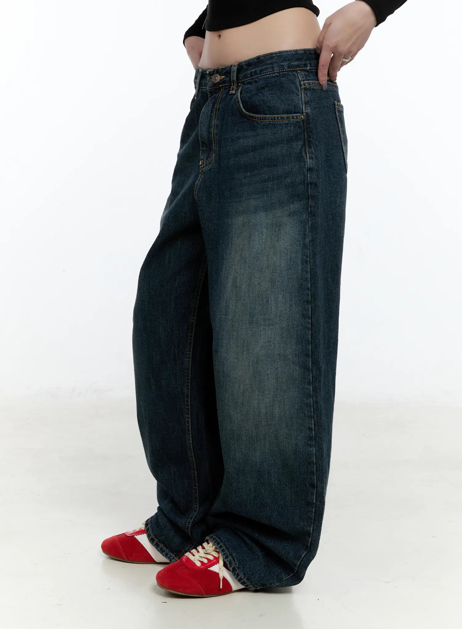 Hunter Washed Wide Leg Jeans CN517 in dark blue, side view on model, showing dramatic wide-leg silhouette and washed fading, paired with black crop top and red sneakers.