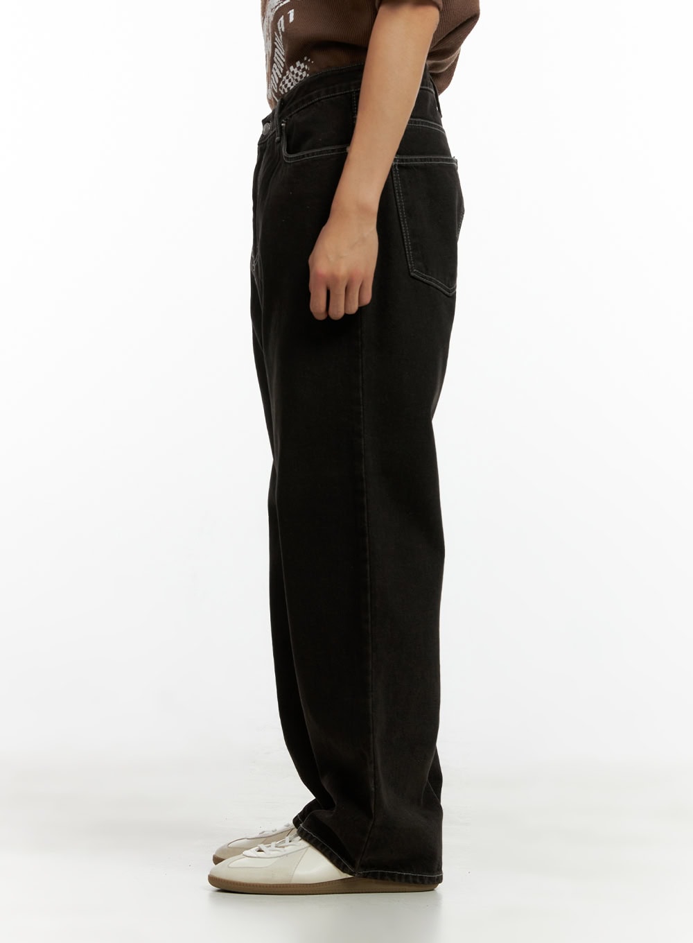 Men's Wide Fit Washed Baggy Jeans CL429 in Black, side view on model, wide-leg washed denim with visible contrast seam stitching, paired with brown tee and white sneakers.