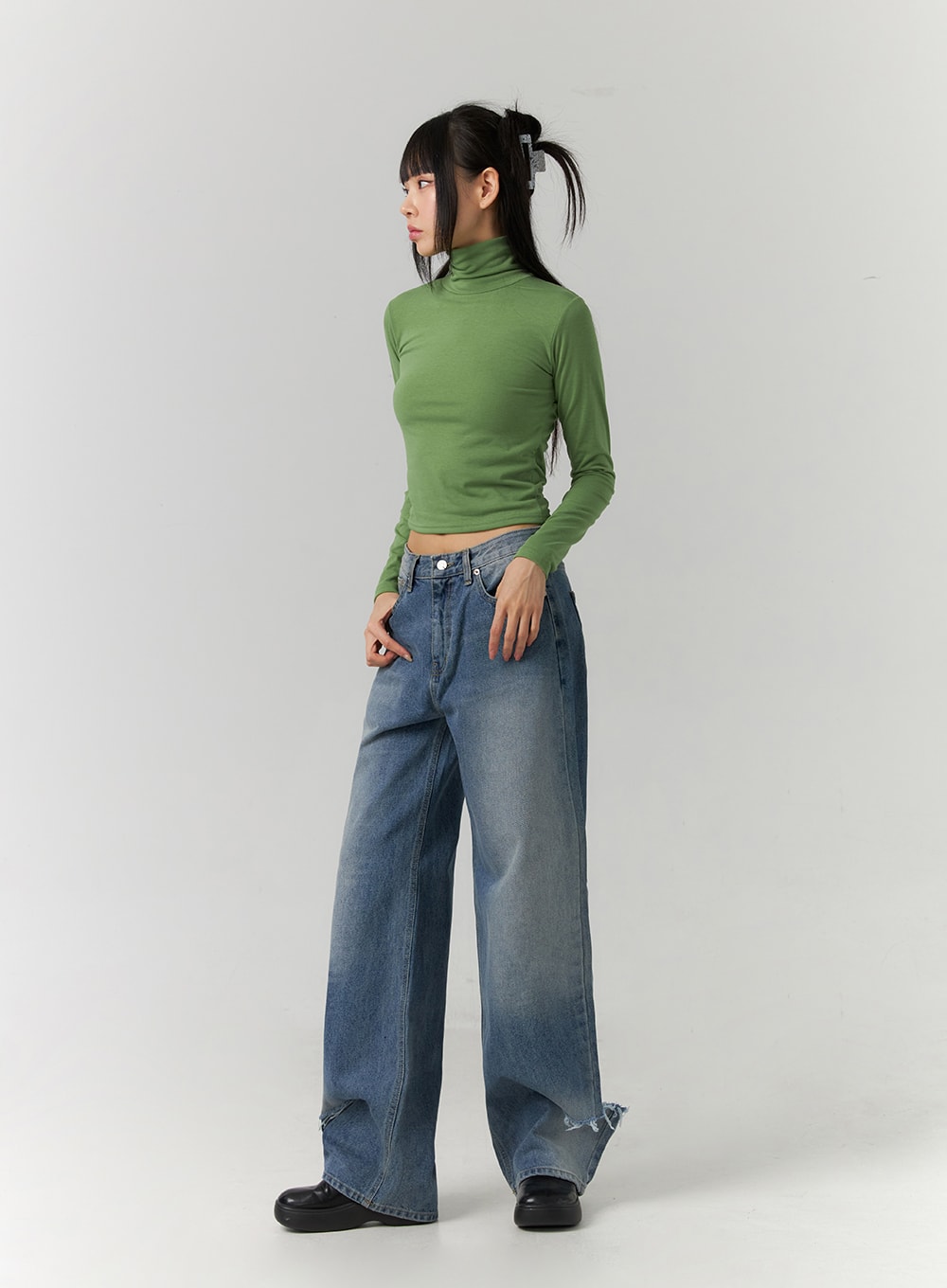 Ripped Straight Leg Jeans CD308 in blue, 3/4 side-angle full-body shot on model, wide-fit washed denim showing destroyed hem detail at ankle, styled with green turtleneck crop top.