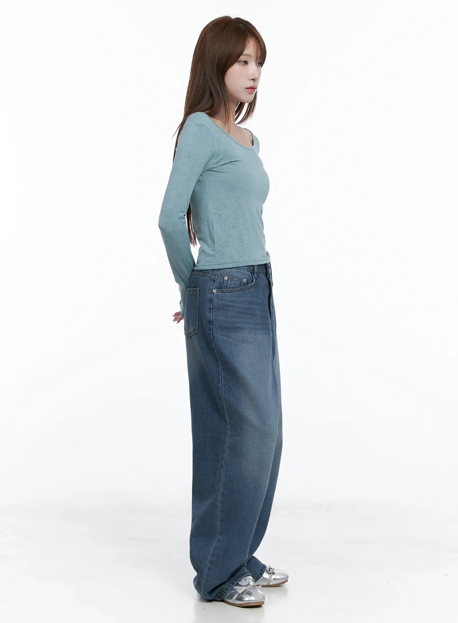 Margot Low-Rise Washed Wide-Leg Jeans CS501 in dark blue, side view on model, low-rise waist and voluminous wide leg visible, paired with teal fitted top and silver sandals.