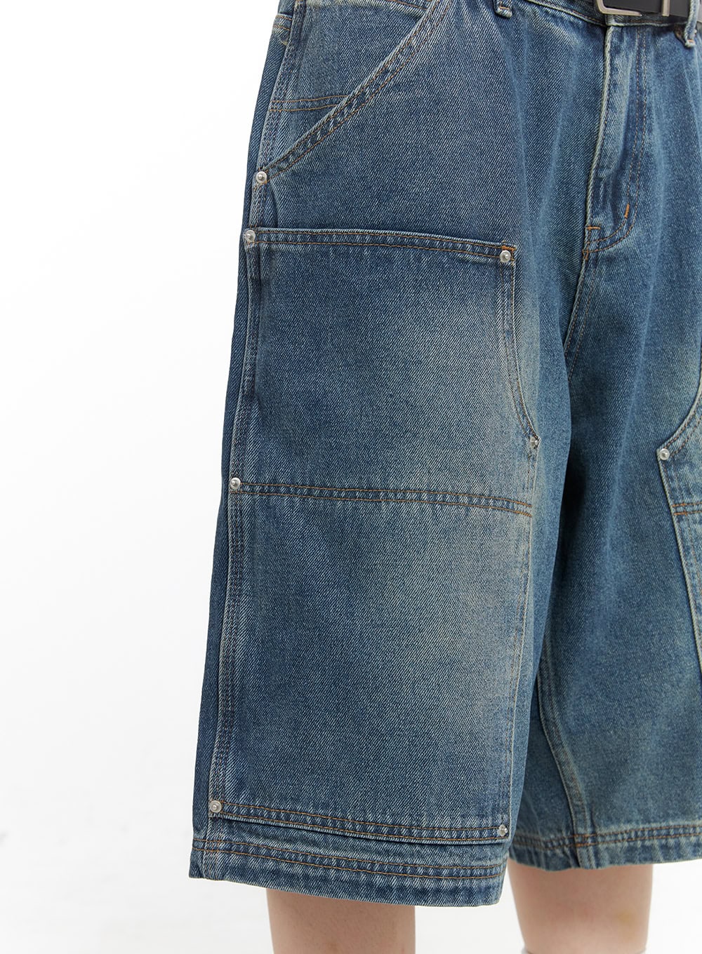 Stud Washed Baggy Jorts (UNISEX) CG408 in blue, close-up detail of left carpenter pocket, showing stud hardware, contrast stitching, and washed cotton denim texture.