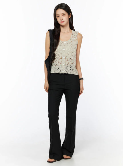 Crochet Knit Sleeveless Top CU522 in beige, full-body front view on model, cropped silhouette with open-knit crochet texture, styled with black flare trousers and sandals.