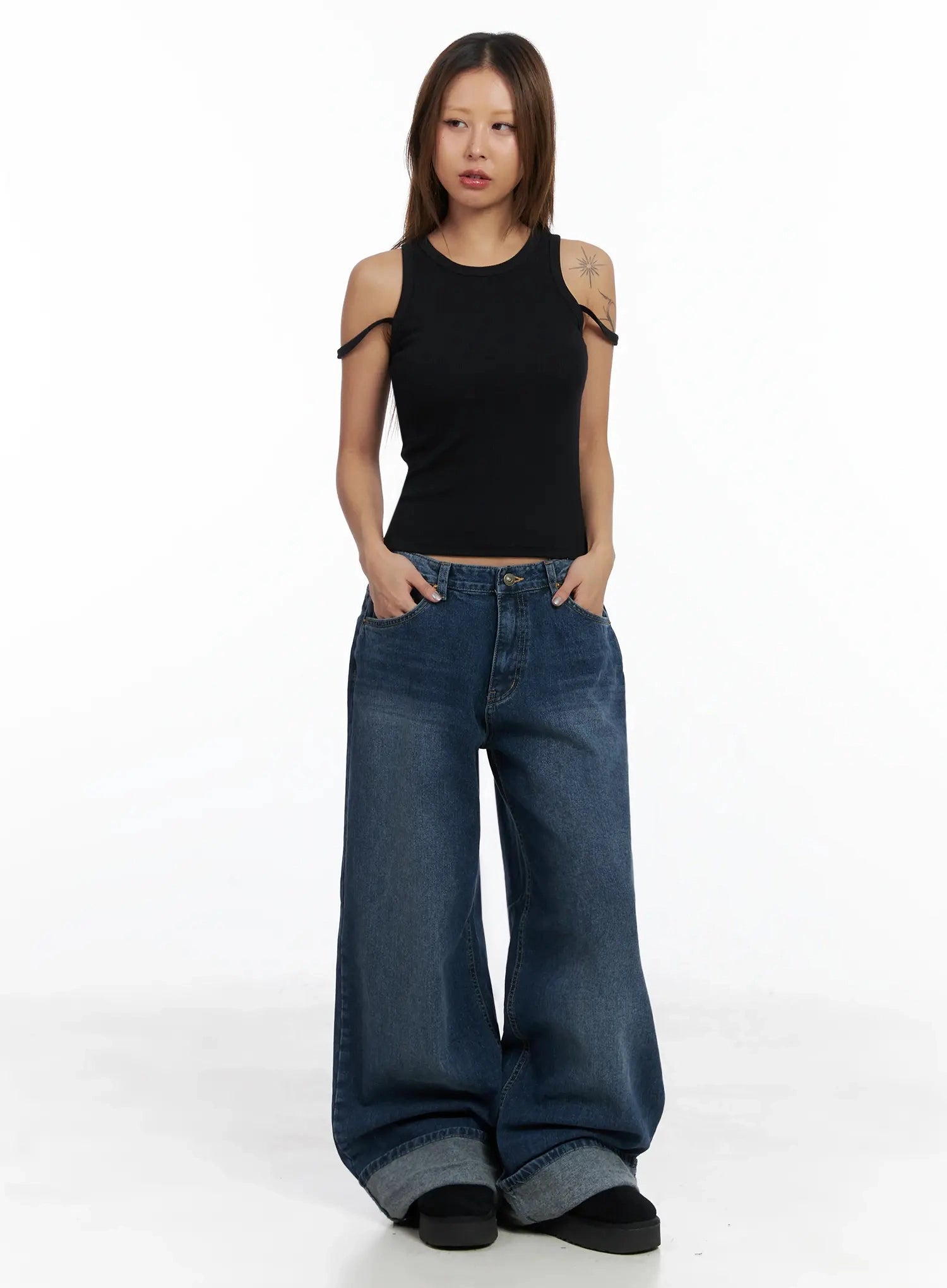 Anahi Baggy Jeans IN528 in blue, front full-length shot on model, wide baggy fit with chunky rolled cuff, styled with black cold-shoulder crop tank.